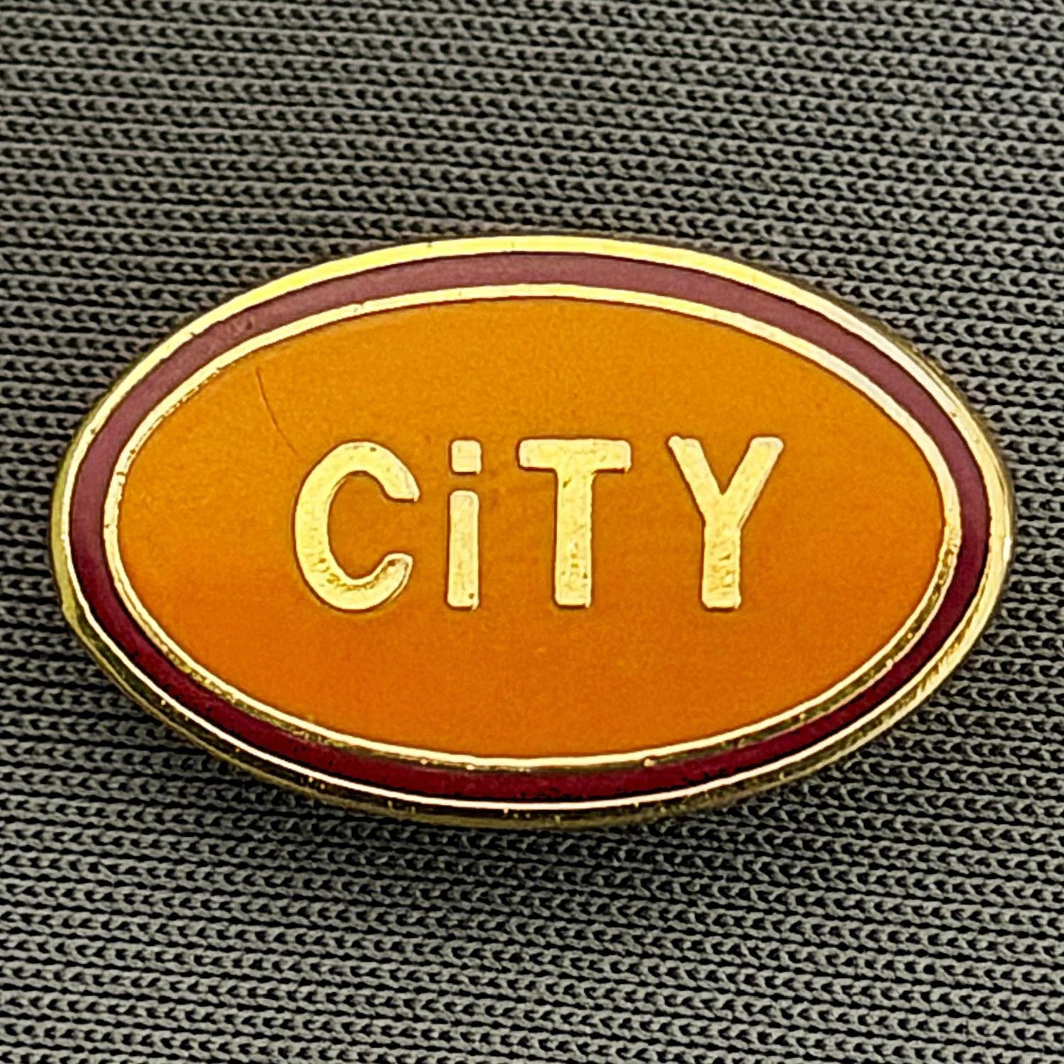 Reference Number: BCBCFC025
Size: H 12.3 mm x W 19.9 mm
Pin Type: Brooch Pin
Plating: Gold
Value: £6
Manufacturer: Unknown
Comments: Oval City, Amber Version