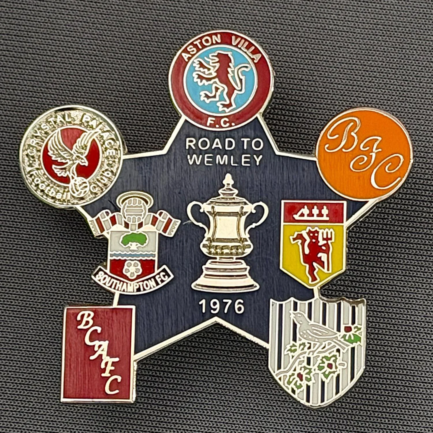 Reference Number: BCFAC045
Size: H 40.8 mm x W 42.1 mm
Pin Type: Double Metal Clutch
Plating: Silver
Value: £5
Manufacturer: Dan Lloyd
Comments: Road to Wembley 1976  Dark Blue Version