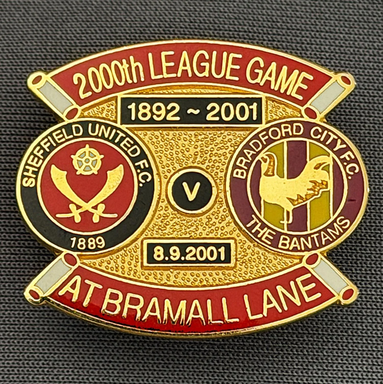 Reference Number: BCOFIX066
Size: H 28.4 mm x W 24.5 mm
Pin Type: Brooch Pin
Plating: Gold
Value: £10
Manufacturer: Unknown
Comments: Sheffield United v Bradford City, 2000th League Game 2001.Claret, Amber & Red Version