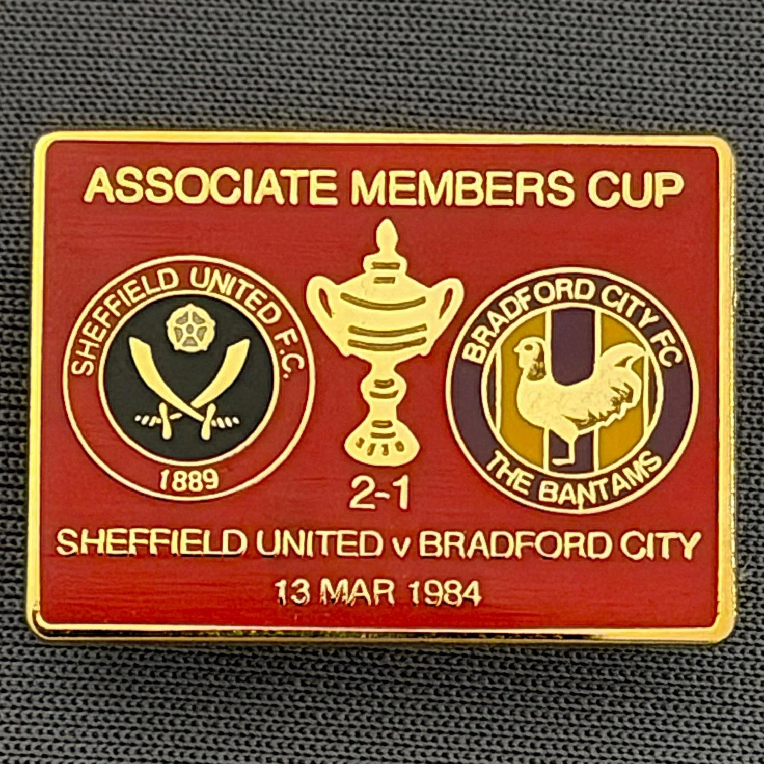Reference Number: BCOFIX063
Size: H 18.9 mm x W 25.9 mm
Pin Type: Brooch Pin
Plating: Gold
Value: £6
Manufacturer: Unknown
Comments: Sheffield United v Bradford City Associate Members Cup 1984, Red Version