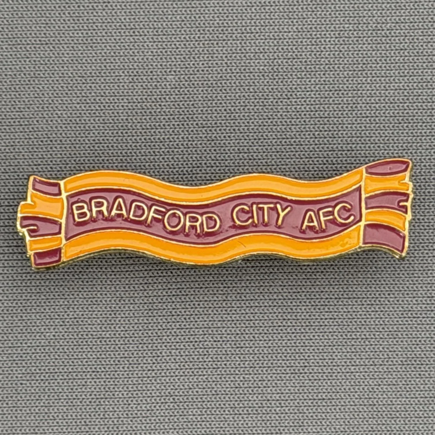 Reference Number: BCSCA005
Size: H 8 mm x W 35 mm
Pin Type: Brooch Pin
Plating: Gold
Value: £6
Manufacturer: Bradford City Shop
Comments: Claret & Amber Scarf
