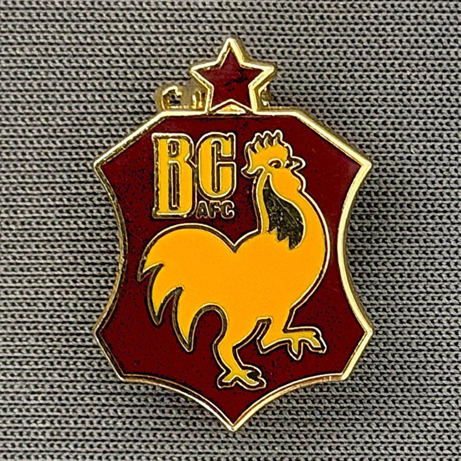 Reference Number: BCBAN039
Size: H 20 mm x W 14.2 mm
Pin Type: Brooch Pin
Plating: Gold
Value: £6
Manufacturer: Unknown
Comments: Claret & Amber, Bantam Crest Shield, Small Version