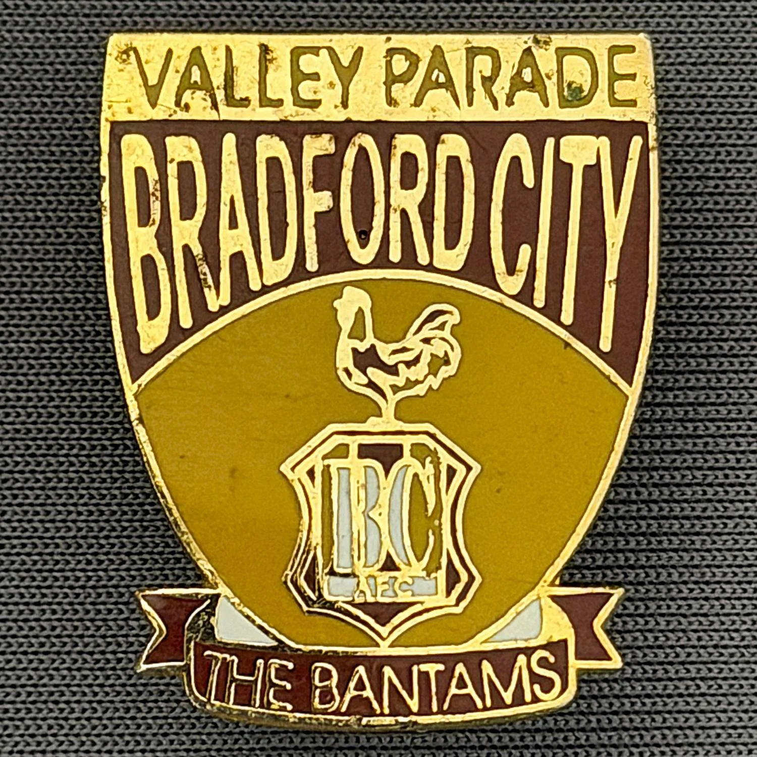 Reference Number: BCMUL011
Size: H 15.2 mm x W 19.9 mm
Pin Type: Brooch Pin
Plating: Gold
Value: £6
Manufacturer: Unknown
Comments: Claret & Amber, Valley Parade, Bradford City, The Bantams