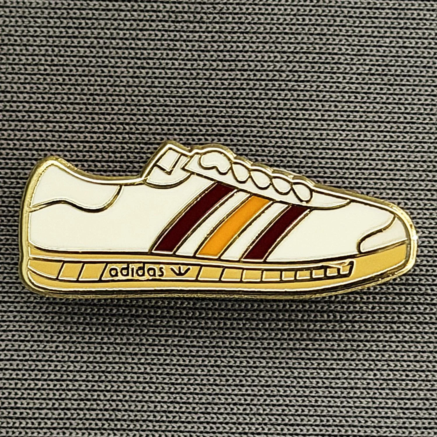 Reference Number: BCUN047
Size: H 9.9 mm x W 24.8 mm
Pin Type: Brooch Pin
Plating: Gold
Value: £4
Manufacturer: Unknown
Comments: White, Claret & Amber Trainer, Small Version