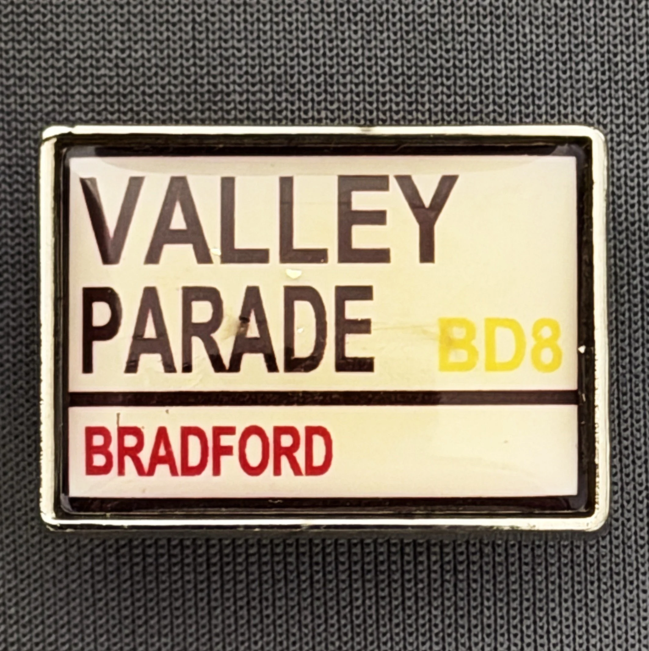 Reference Number: BCVP012
Size: H 18.3 mm x W 25.5 mm
Pin Type: Metal Clutch
Plating: Silver
Value: £6
Manufacturer: 
Comments: Valley Parade Road Sign