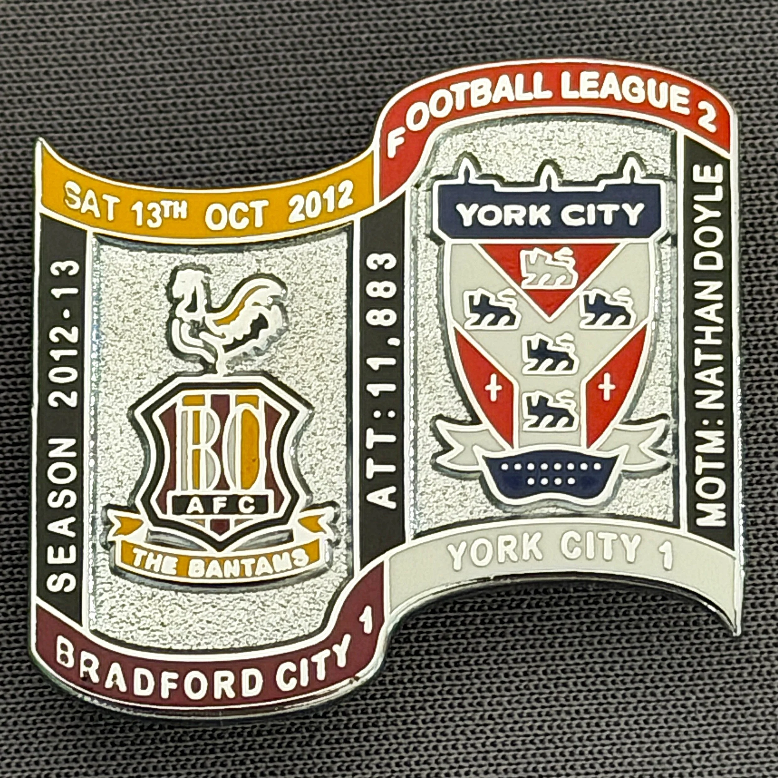 Reference Number: BCFIX144
Size: H 26.9 mm x W 29.2 mm
Pin Type: Brooch Pin
Plating: Chrome
Value: £10
Manufacturer: Bradford City Badges
Comments: Bradford City v York City  2012/13 Limited Edition 10 Badges (Silver Version)