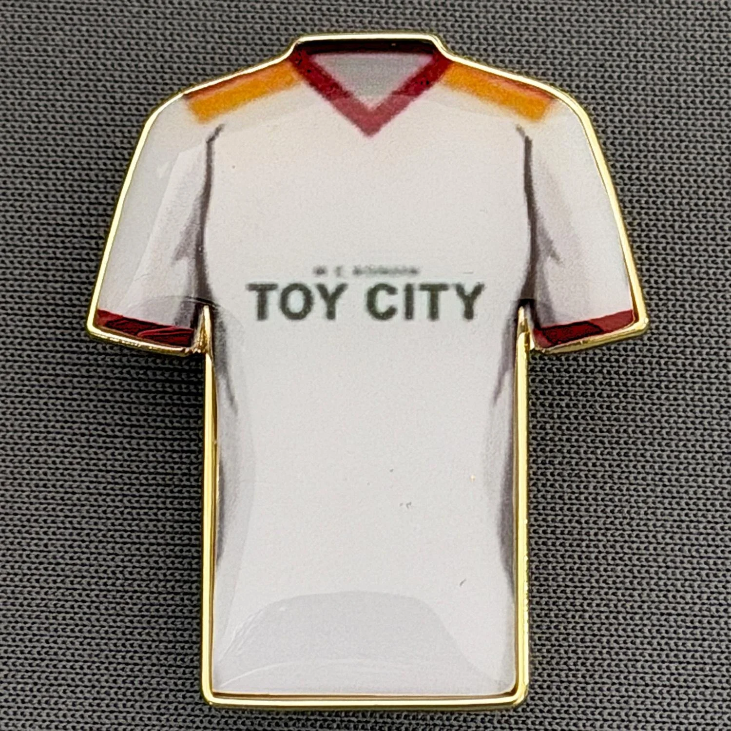 Reference Number: BCKIT090
Size: H 33 mm x W 27.1 mm
Pin Type: Metal Clutch
Plating: Gold
Value: £4
Manufacturer: Blue Badge Design
Comments: Bradford City 1982/83 Home Kit, Plastic Dome
