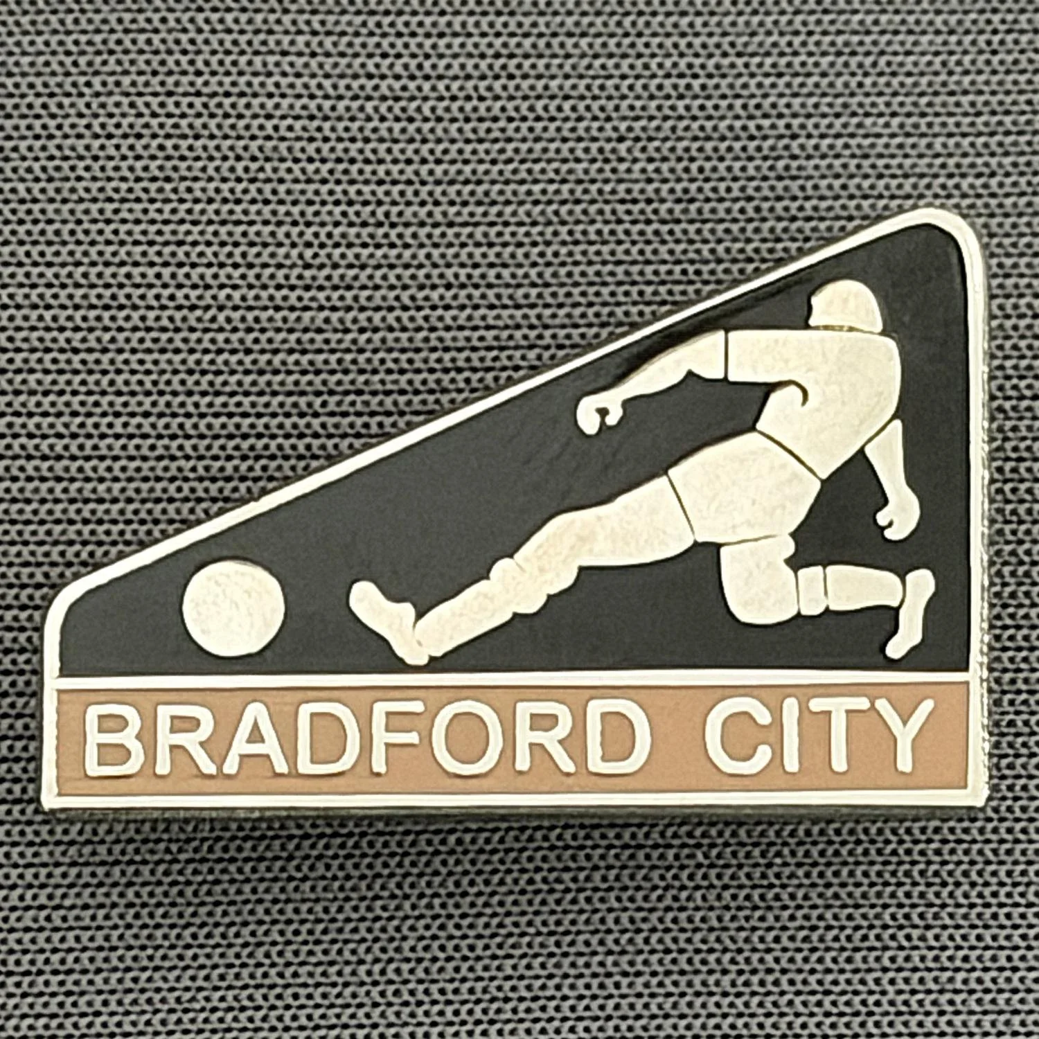 Reference Number: BCBCFC080
Size: H 17.3 mm x W 26.2 mm
Pin Type: Brooch Pin
Plating: Silver
Value: £6
Manufacturer: Andy Stokes
Comments: Black & Coffee Bradford City Footballer
