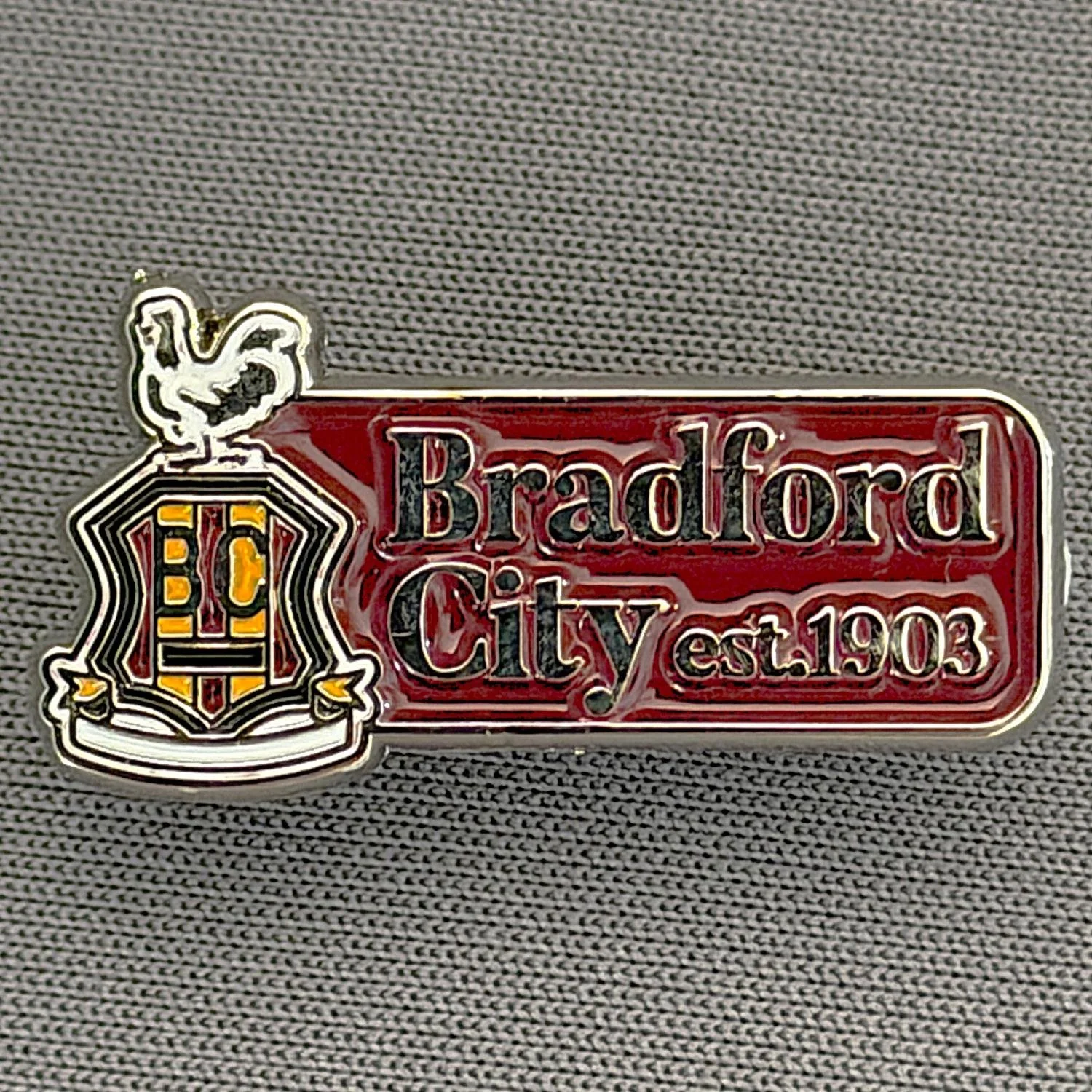 Reference Number: BCC&L165
Size: H 13.1 mm x 25.8 mm
Pin Type: Metal Clutch
Plating: Silver
Value: £6
Manufacturer: Bradford City Shop
Comments: Bradford City Est 1903