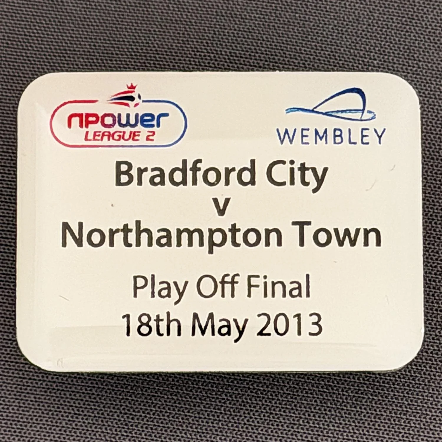 Reference Number: BCOFIX024
Size: H 24.3 mm x W 32.2 mm
Pin Type: Metal Clutch
Plating: Aluminium
Value: £6
Manufacturer: Wembley Stadium
Comments: Official League 2 Play Off Final City v Northampton Town 2013, Plastic Dome