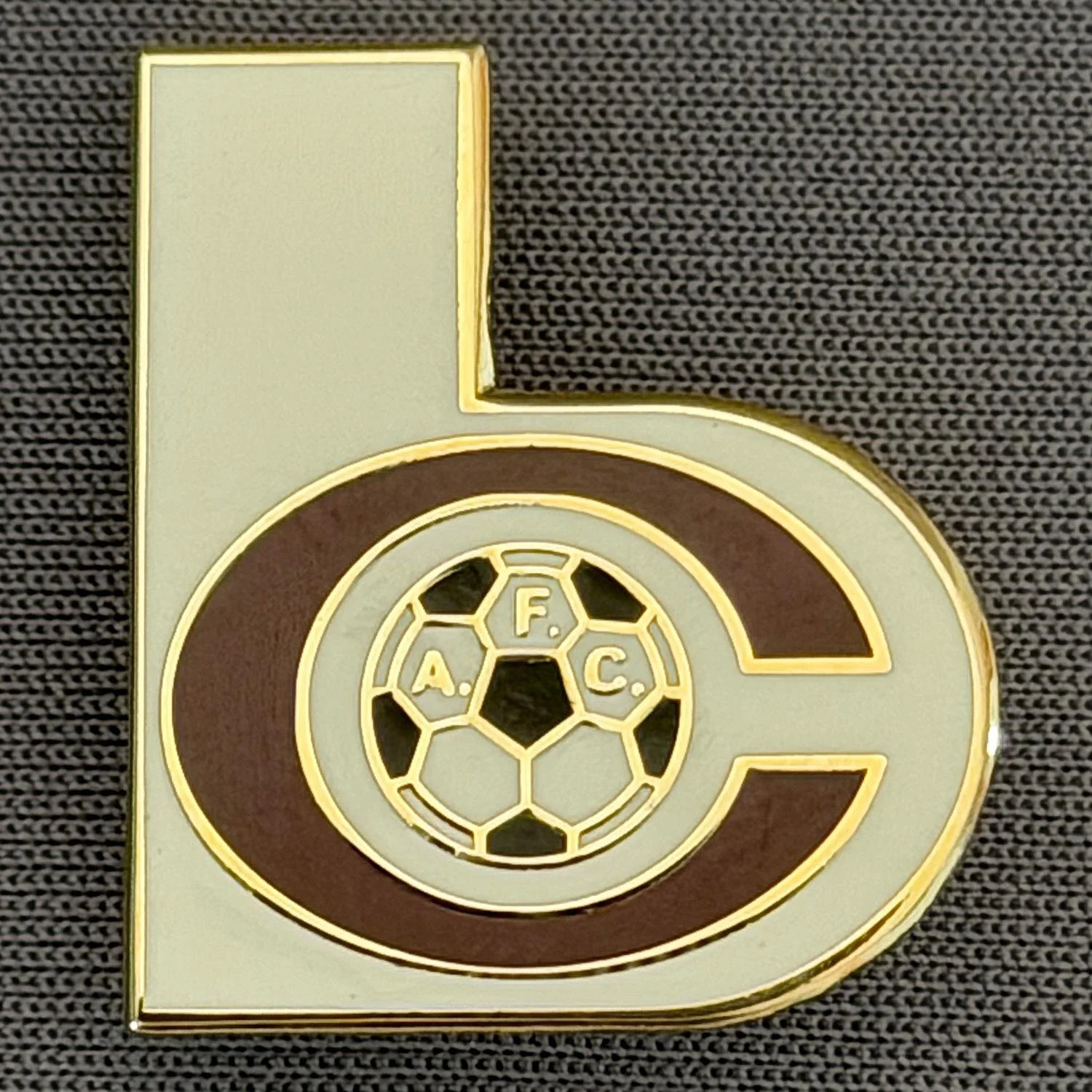 Reference Number: BCC&L153
Size: H 22.8 mm x 19.7 mm
Pin Type: Brooch Pin
Plating: Gold
Value: £6
Manufacturer: Unknown
Comments: Shaped White & Claret BC Logo