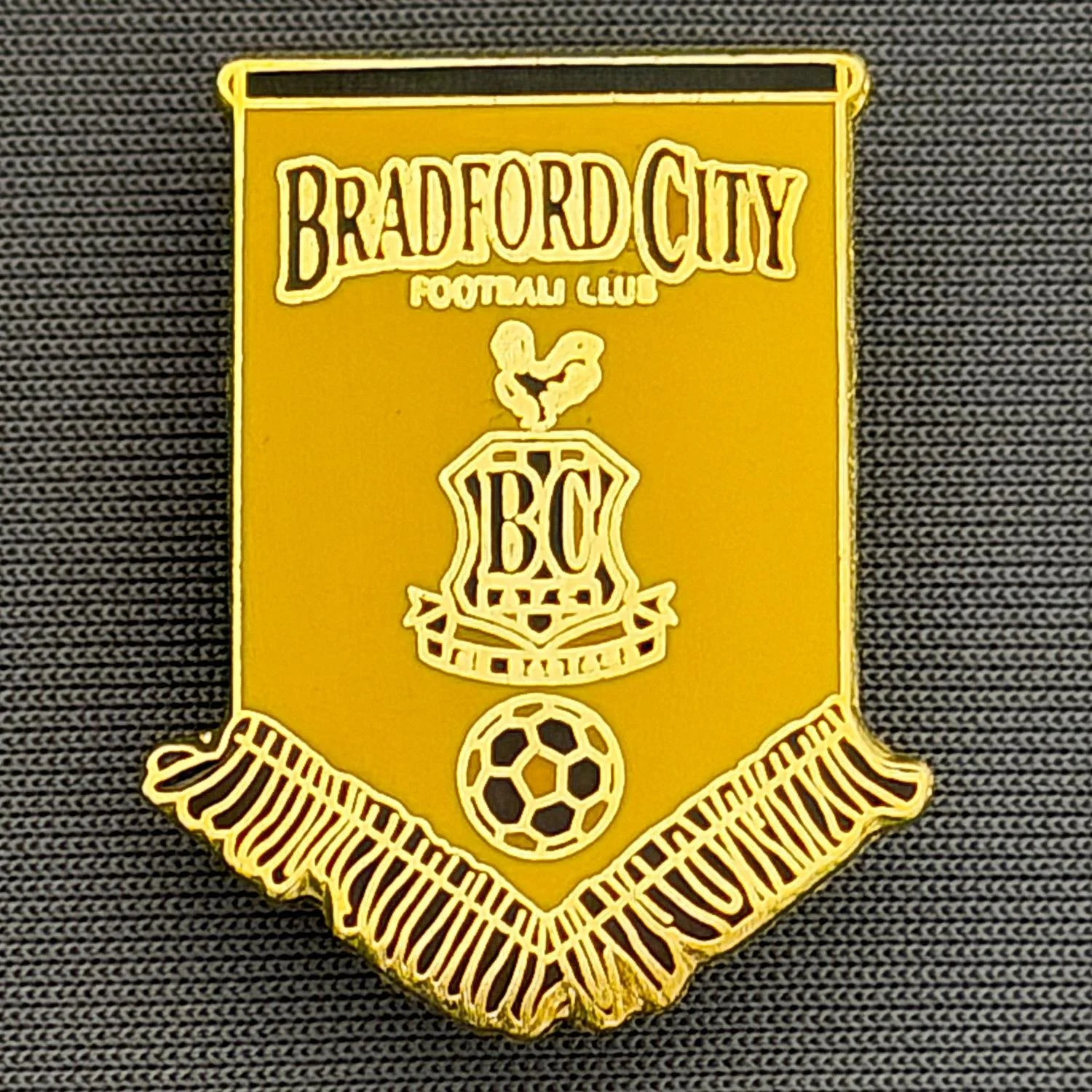 Reference Number: BCBCFC061
Size: H 28.1 mm x W 22.1 mm
Pin Type: Brooch Pin
Plating: Gold
Value: £6
Manufacturer: Andy Stokes
Comments: Amber & Claret Bradford City Pennant