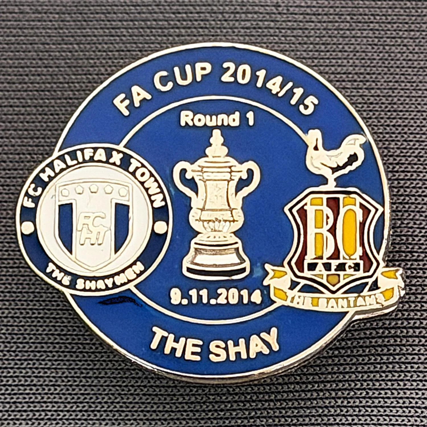Reference Number: BCFAC058
Size: H 22. 7 mm x W 25.8 mm
Pin Type: Metal Clutch
Plating: Silver
Value: £4
Manufacturer: Dan Lloyd
Comments: F.A. Cup 2014/15 Away v Halifax Town, Blue Version