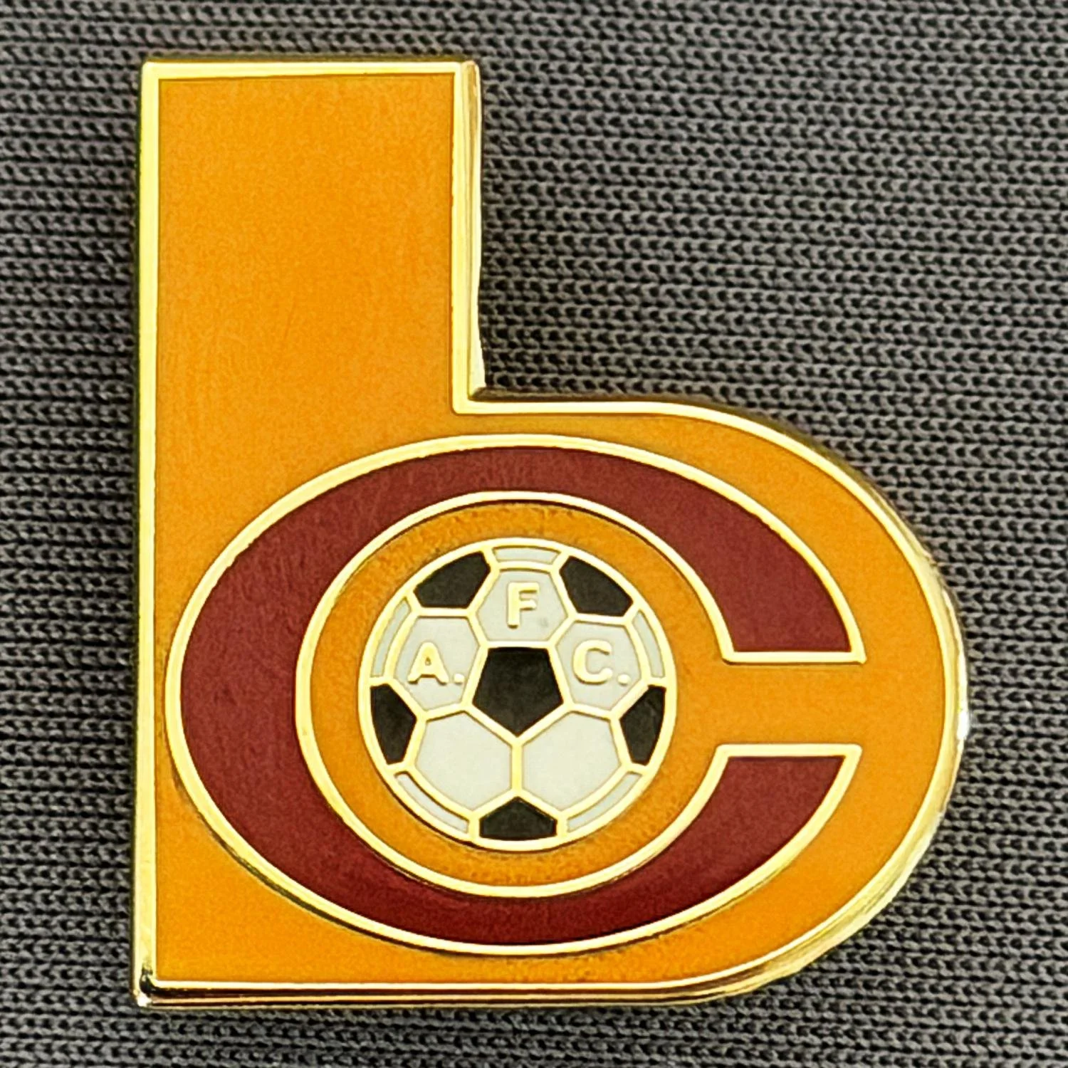 Reference Number: BCC&L151
Size: H 22.8 mm x 19.7 mm
Pin Type: Brooch Pin
Plating: Gold
Value: £6
Manufacturer: Unknown
Comments: Shaped Amber & Claret BC Logo