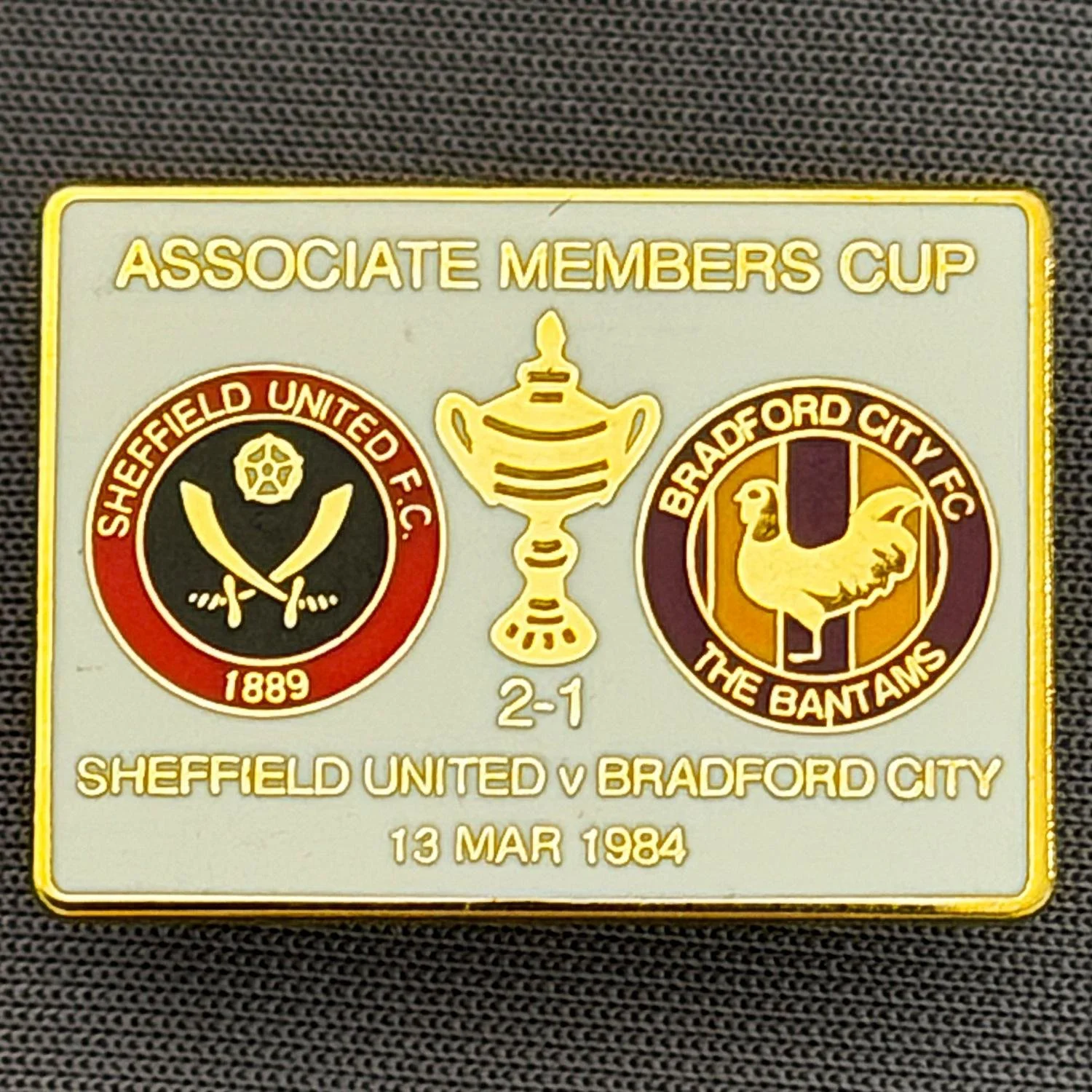 Reference Number: BCOFIX059
Size: H 18.9 mm x W 25.9 mm
Pin Type: Brooch Pin
Plating: Gold
Value: £6
Manufacturer: Unknown
Comments: Sheffield United v Bradford City Associate Members Cup 1984, White Version