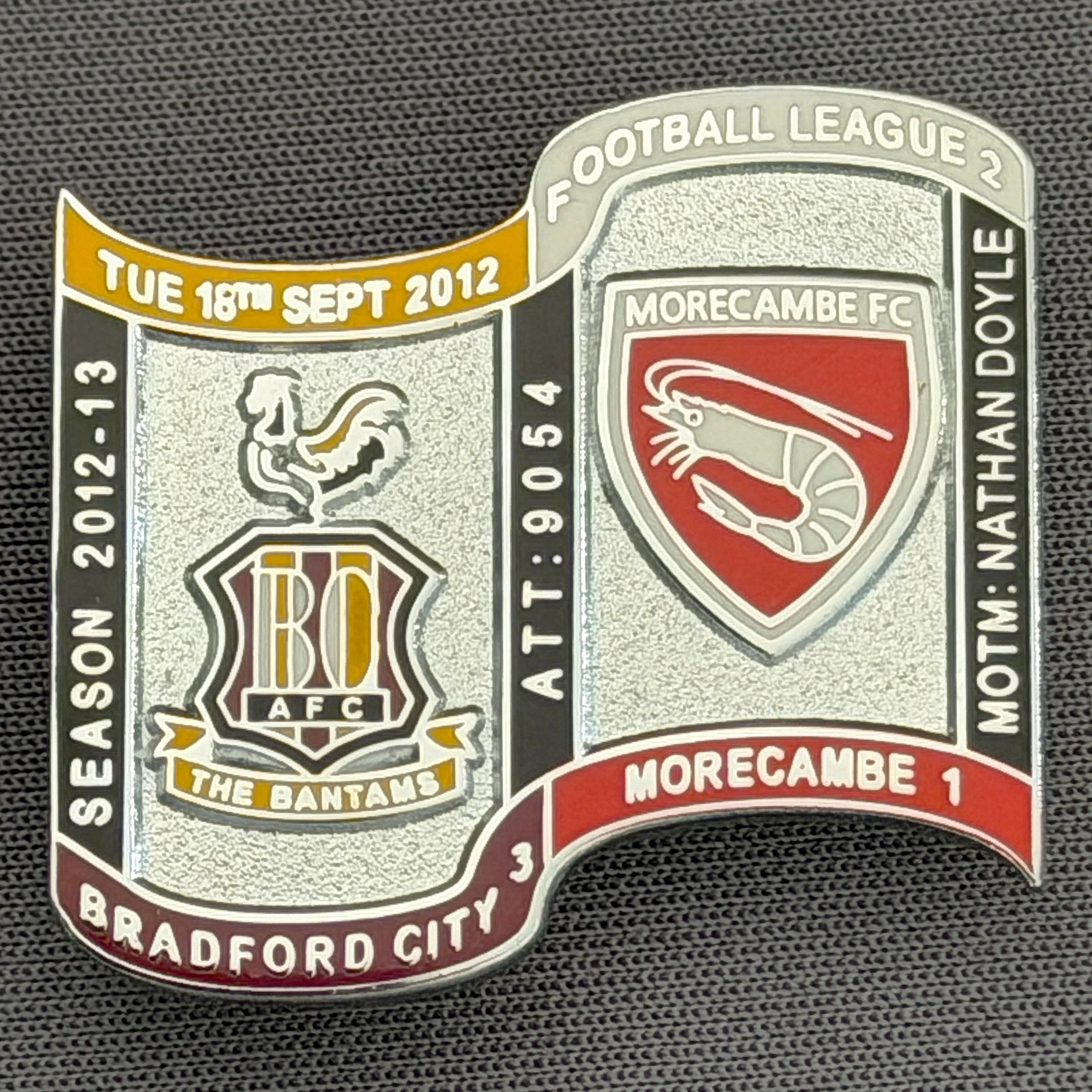 Reference Number: BCFIX142
Size: H 26.9 mm x W 29.2 mm
Pin Type: Brooch Pin
Plating: Chrome
Value: £10
Manufacturer: Bradford City Badges
Comments: Bradford City v Morecambe  2012/13 Limited Edition 10 Badges (Silver Version)