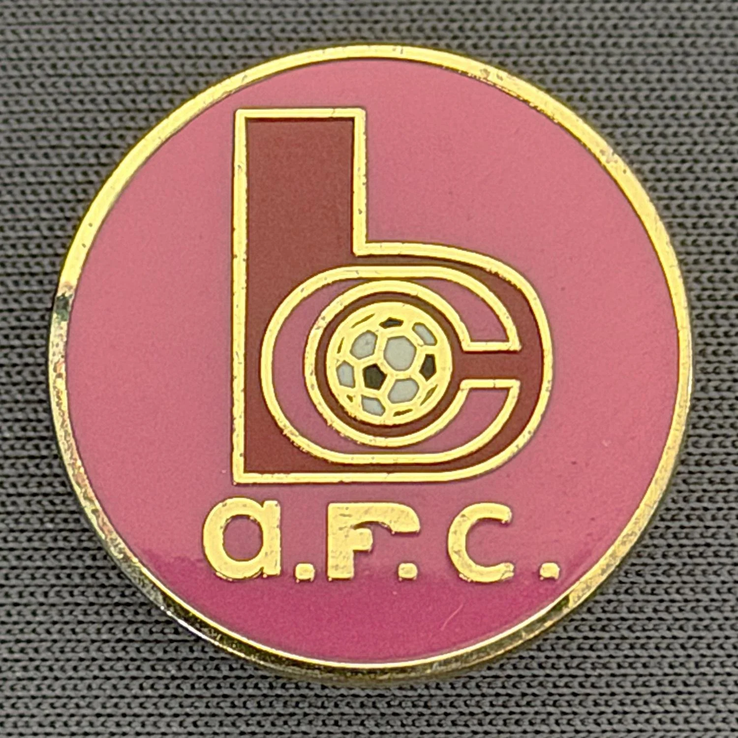 Reference Number: BCC&L140
Size: D 21.1 mm
Pin Type: Brooch Pin
Plating: Gold
Value: £6
Manufacturer: Unknown
Comments: Pink & Red BC Logo Small Version