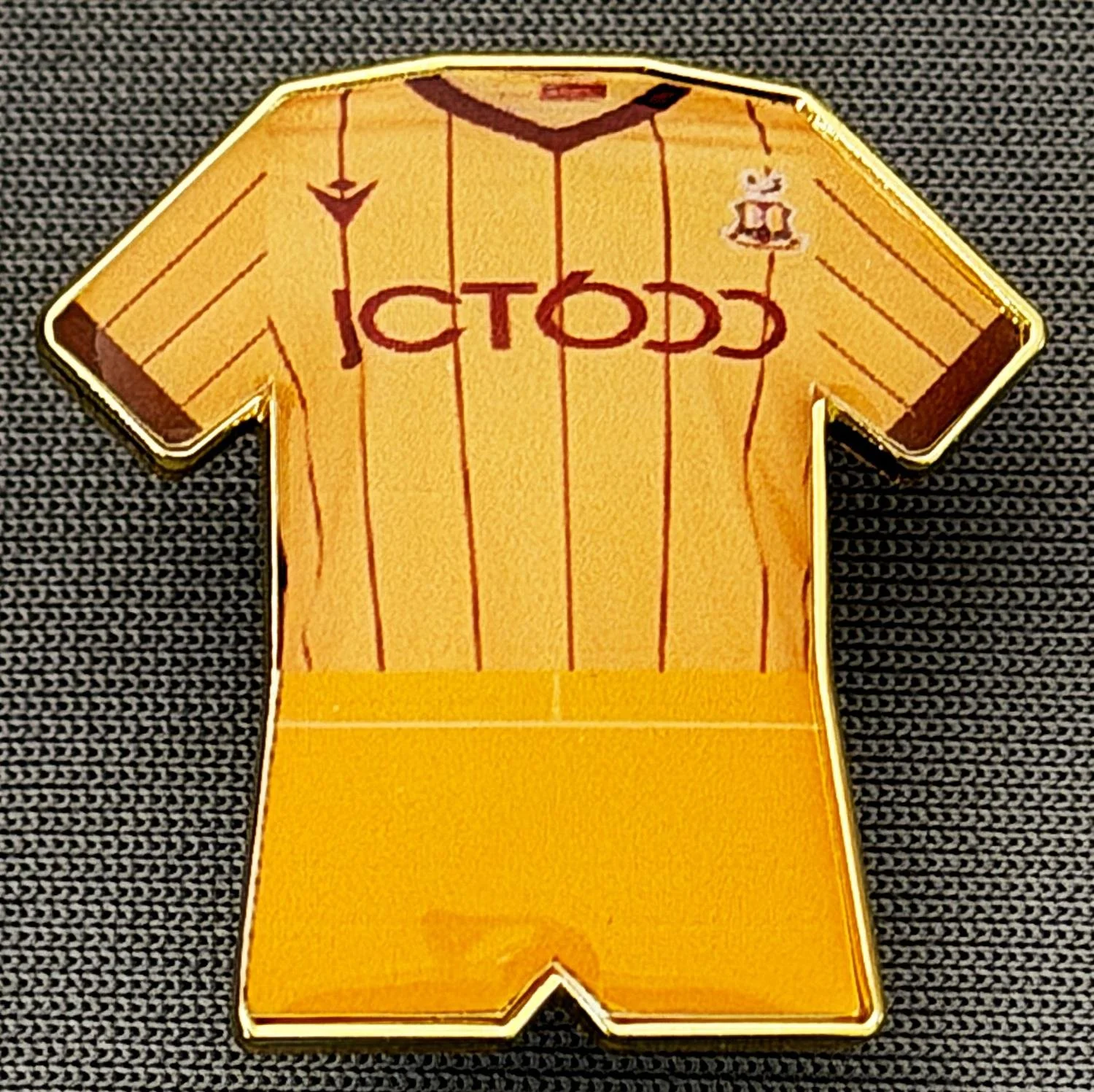 Reference Number: BCKIT042
Size: H 24.9 mm x W 25 mm
Pin Type: Metal Clutch
Plating: Gold
Value: £4
Manufacturer: Blue Badge Design
Comments: 2023/24 Third Goalkeeper Kit Plastic Dome