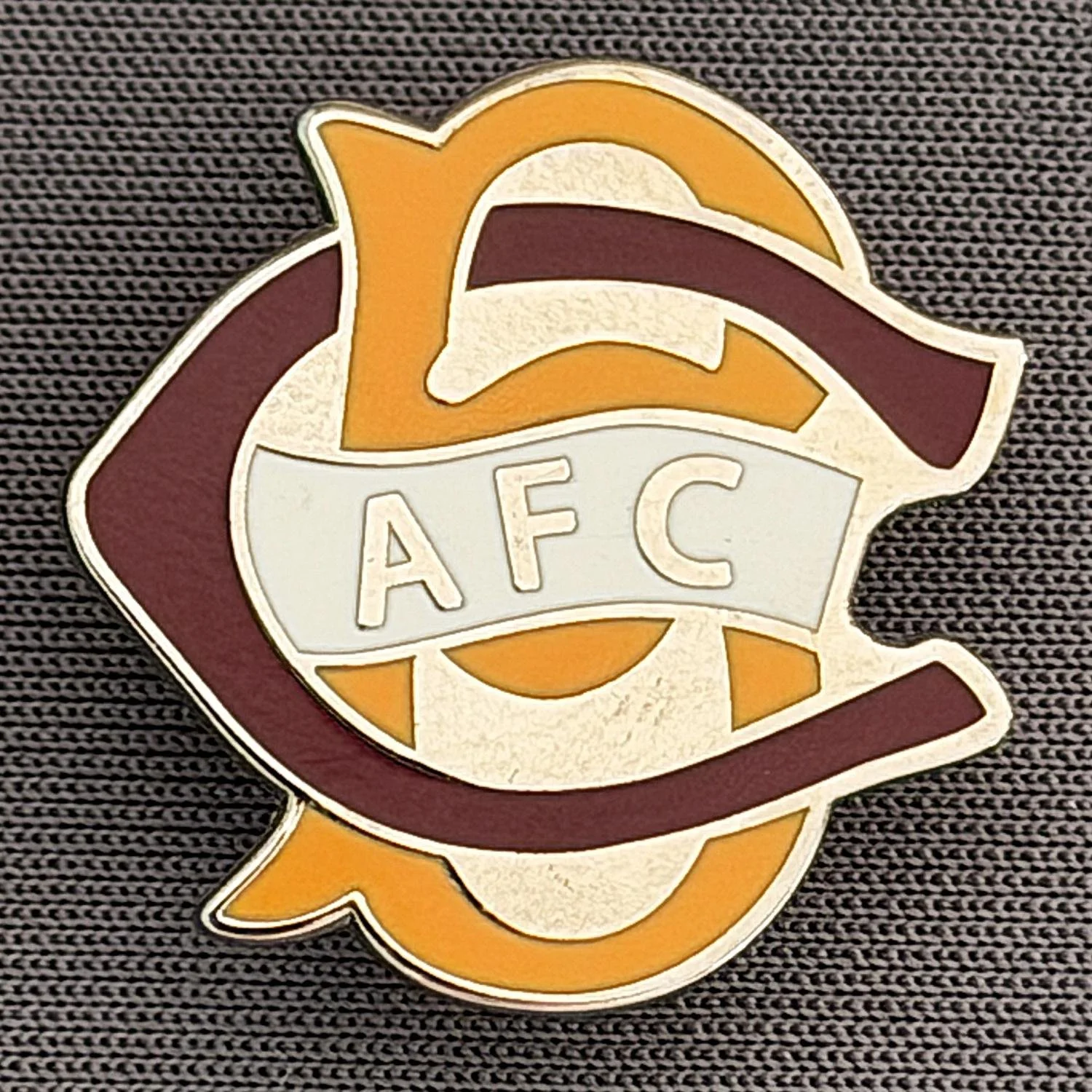 Reference Number: BCC&L067
Size: H 22.1 mm x 22  mm
Pin Type: Brooch Pin
Plating: Silver
Value: £6
Manufacturer: Unknown
Comments: BCFC Ayrton Scroll Claret & Amber