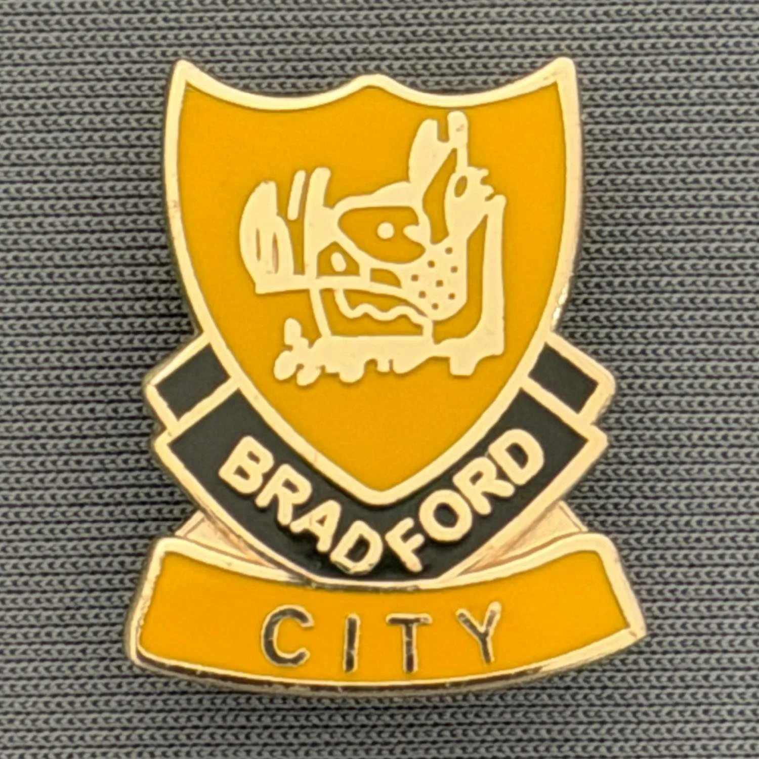 Reference Number: BCBOH064
Size: H 22 x W 18.1 mm
Pin Type: Brooch Pin
Plating: Gold
Value: £6
Manufacturer: Unknown
Comments:  Amber & Black  Boar's Head Shield