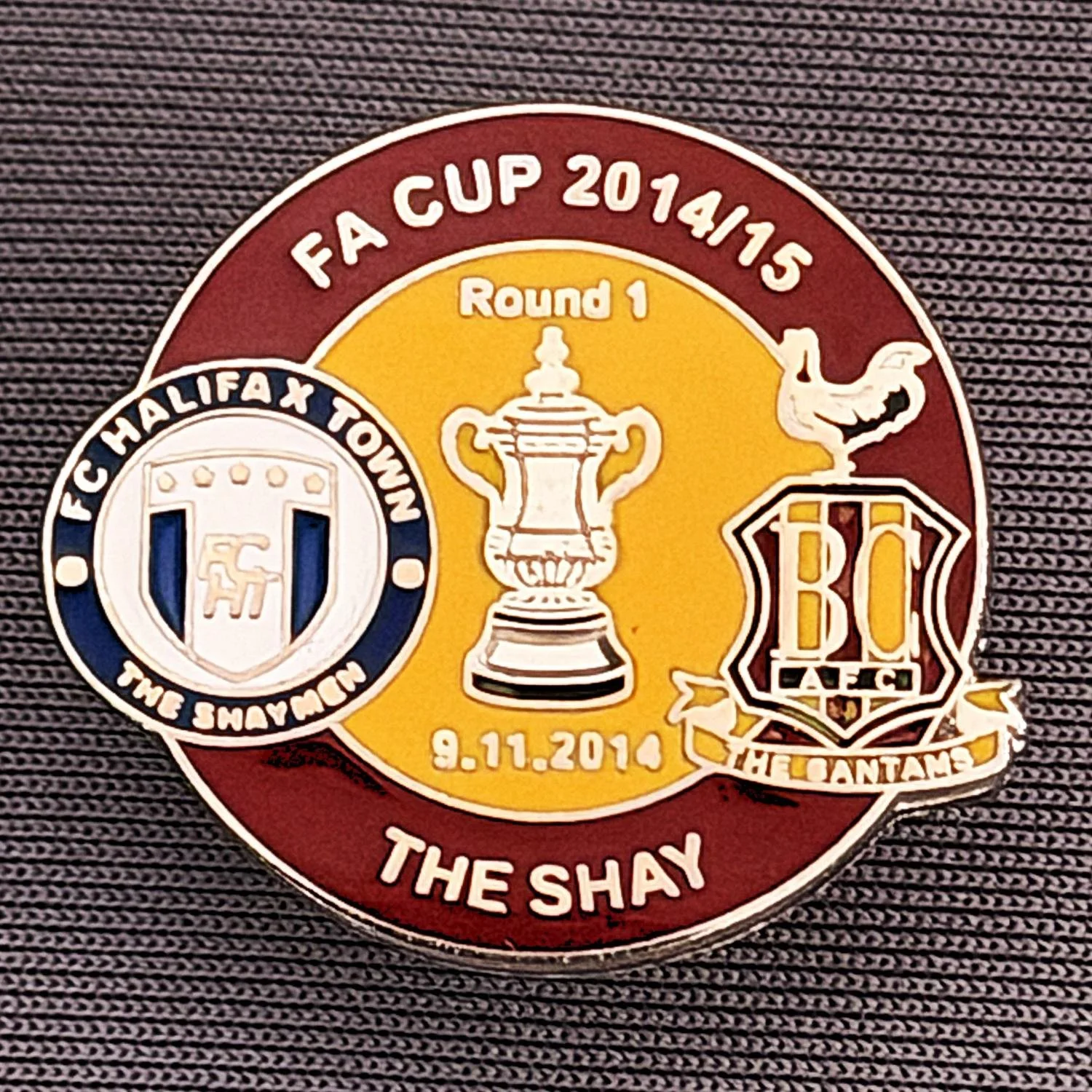 Reference Number: BCFAC051
Size: H 22. 7 mm x W 25.8 mm
Pin Type: Metal Clutch
Plating: Silver
Value: £4
Manufacturer: Dan Lloyd
Comments: F.A. Cup 2014/15 Away v Halifax Town, Claret & Amber Version