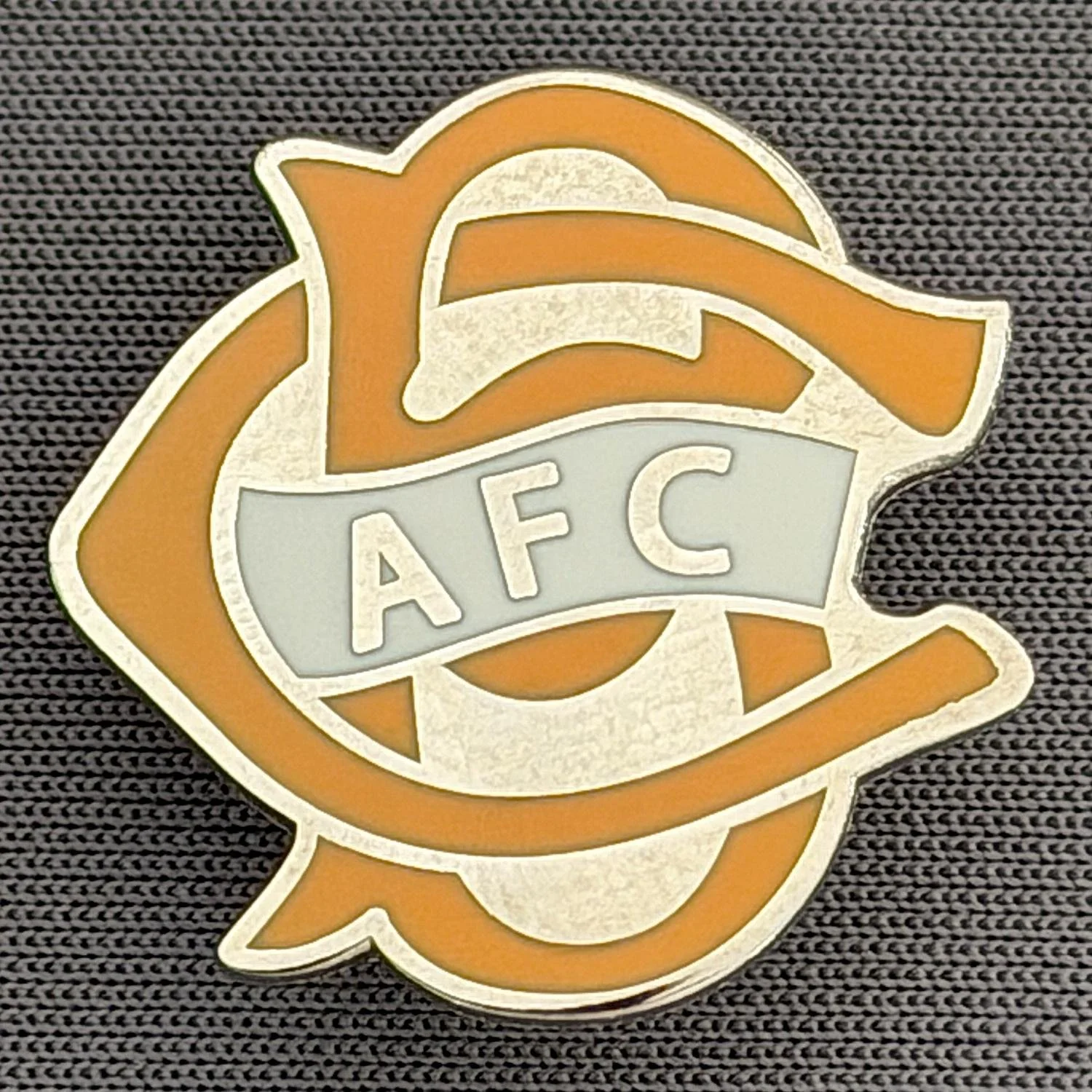 Reference Number: BCC&L068
Size: H 22.1 mm x 22  mm
Pin Type: Brooch Pin
Plating: Silver
Value: £6
Manufacturer: Unknown
Comments: BCFC Ayrton Scroll Amber
