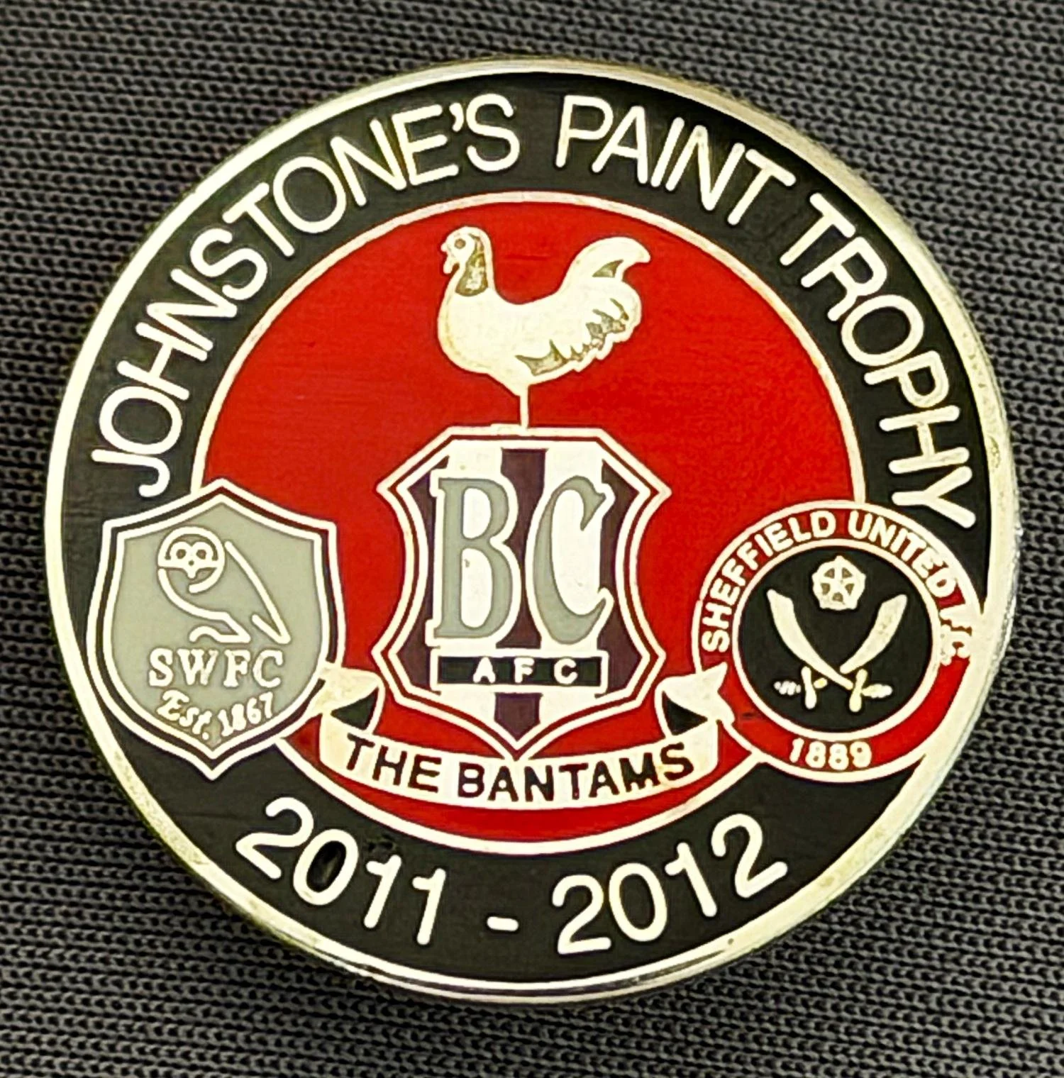 Reference Number: BCOFIX073
Size: D 25.8 mm
Pin Type: Brooch Pin
Plating: Chrome
Value: £5
Manufacturer: Unknown
Comments: Johnstones Paint Trophy 2011/12 Bradford City, Sheff United, Sheffield Wednesday, Black & Red Version