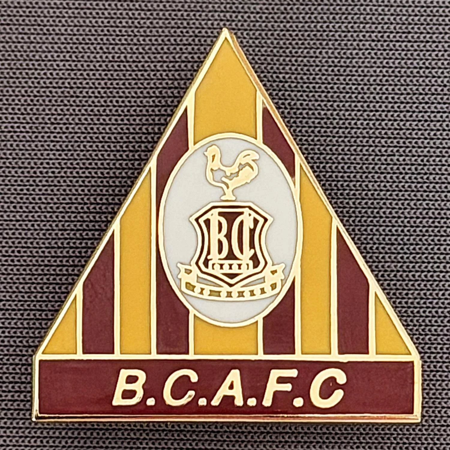 Reference Number: BCC&L049
Size: H 26.1 mm x 25.2 mm
Pin Type: Brooch Pin
Plating: Gold
Value: £8
Manufacturer: Andy Stokes
Comments: Claret & Amber Triangle, City Logo