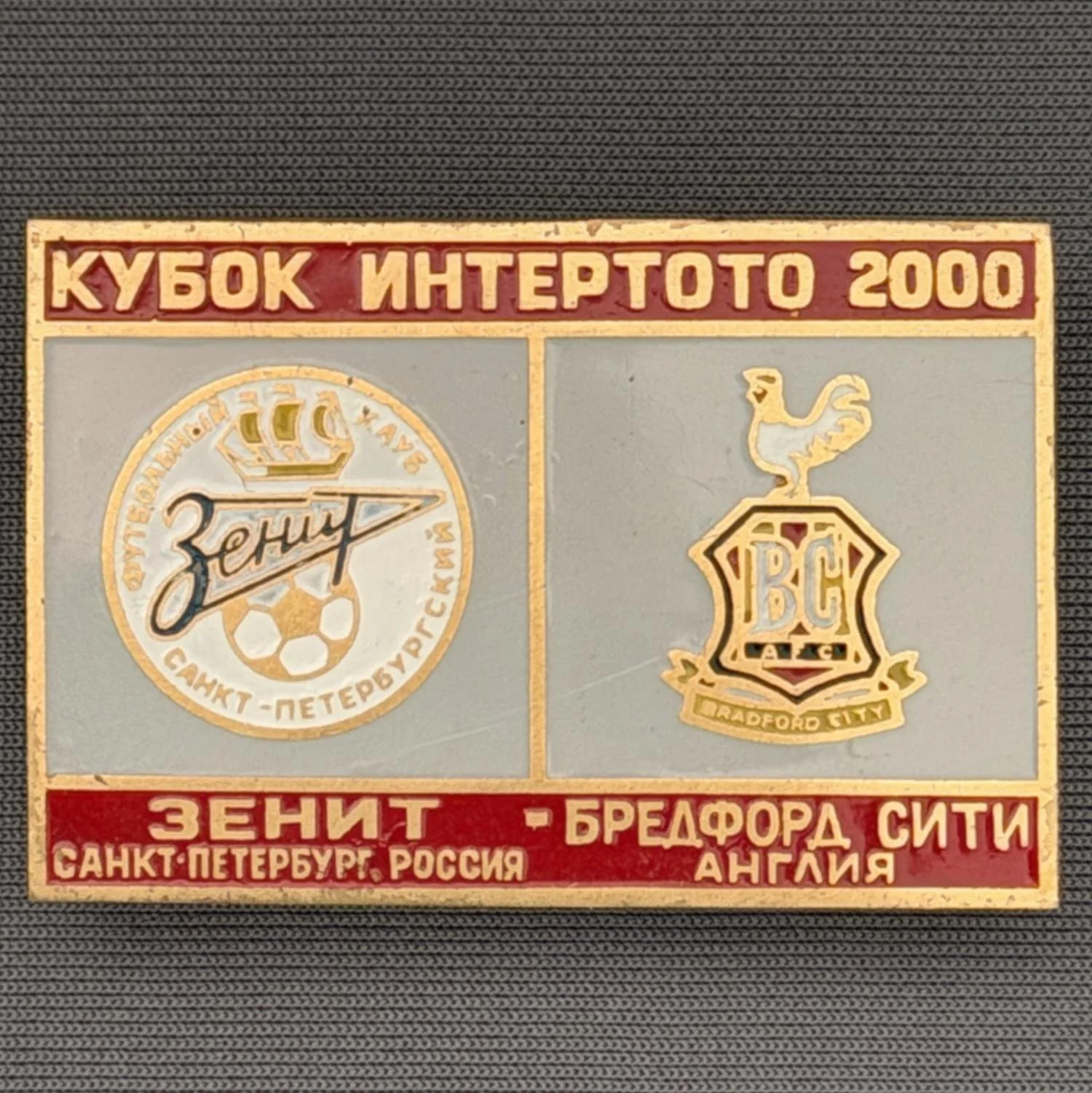 Reference Number: BCRUS022
Size: H 29.6 mm x W 44.6 mm
Pin Type: Metal Clutch
Plating: Antique Gold
Value: £12
Manufacturer: Unknown
Comments: Zenit St. Petersburg Inter Toto Cup, Red Top, Grey Middle, Red Bottom