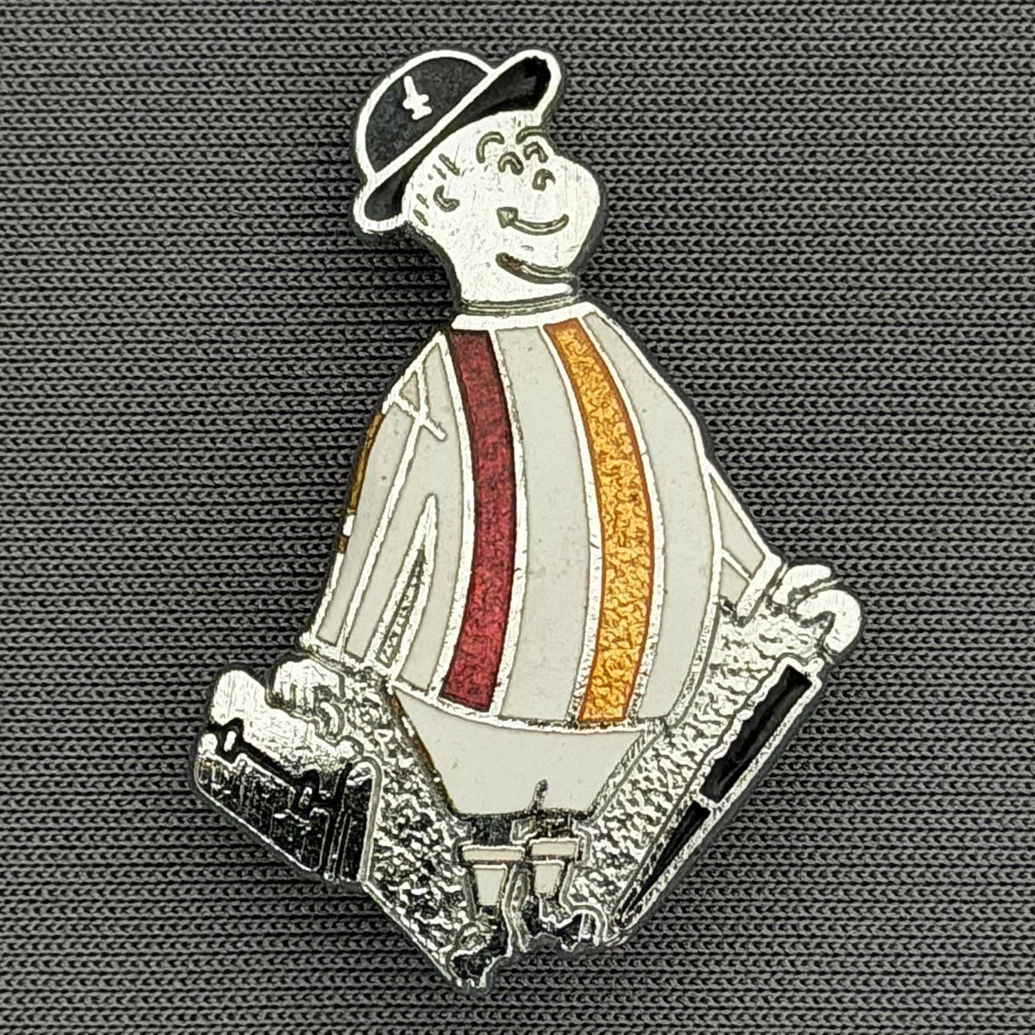 Reference Number: BCGEN005
Size: H 31.2 mm x W 21.1 mm
Pin Type: Brooch Pin
Plating: Silver
Value: £15
Manufacturer: Rojack Stamping
Comments: Classic City Gent Badge, Alternate Shirt, White Shorts. Mid 1980s.
