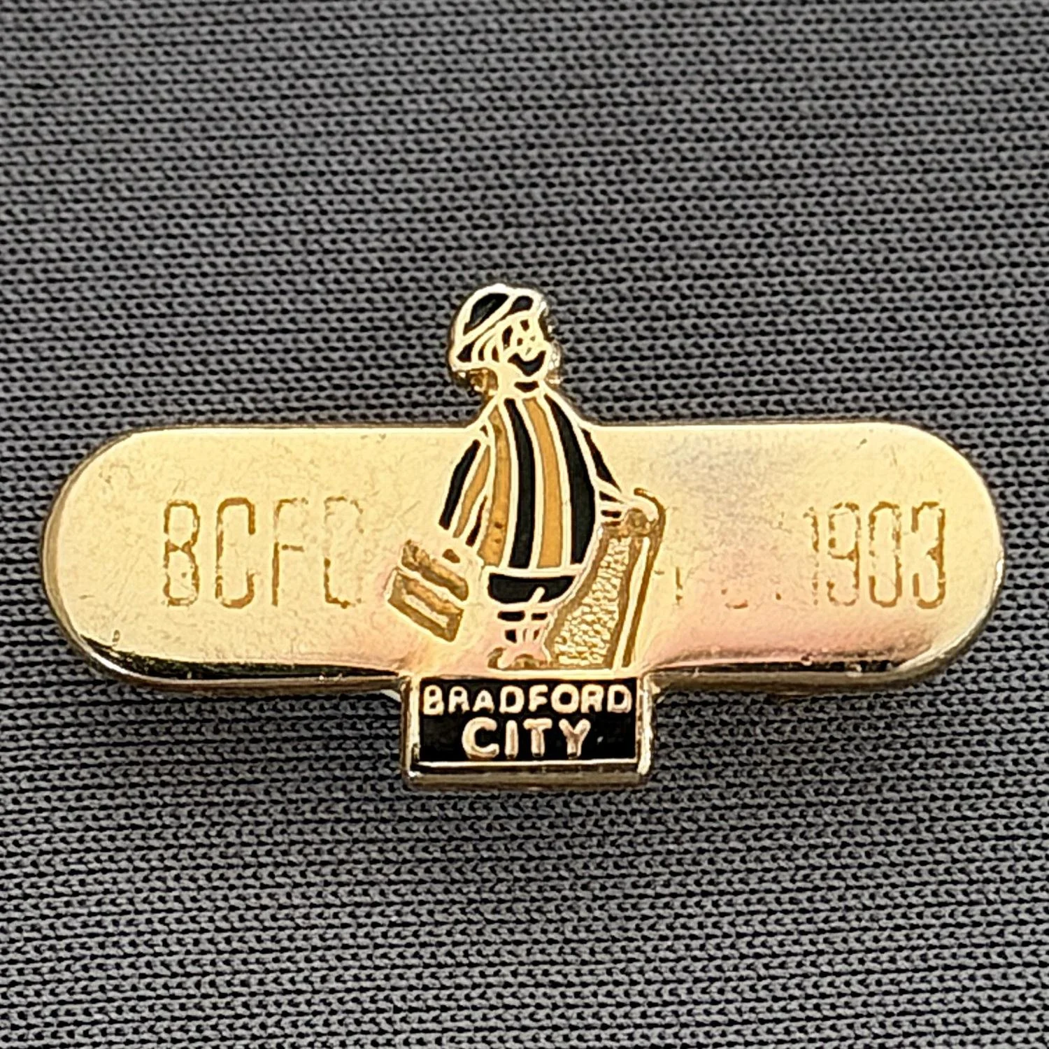 Reference Number: BCGEN028
Size: H 13.2 mm x W 24.8 mm
Pin Type: Brooch Pin
Plating: Gold
Value: £8
Manufacturer: Unknown
Comments: Horizontal Bar, City Gent, Amber Letters