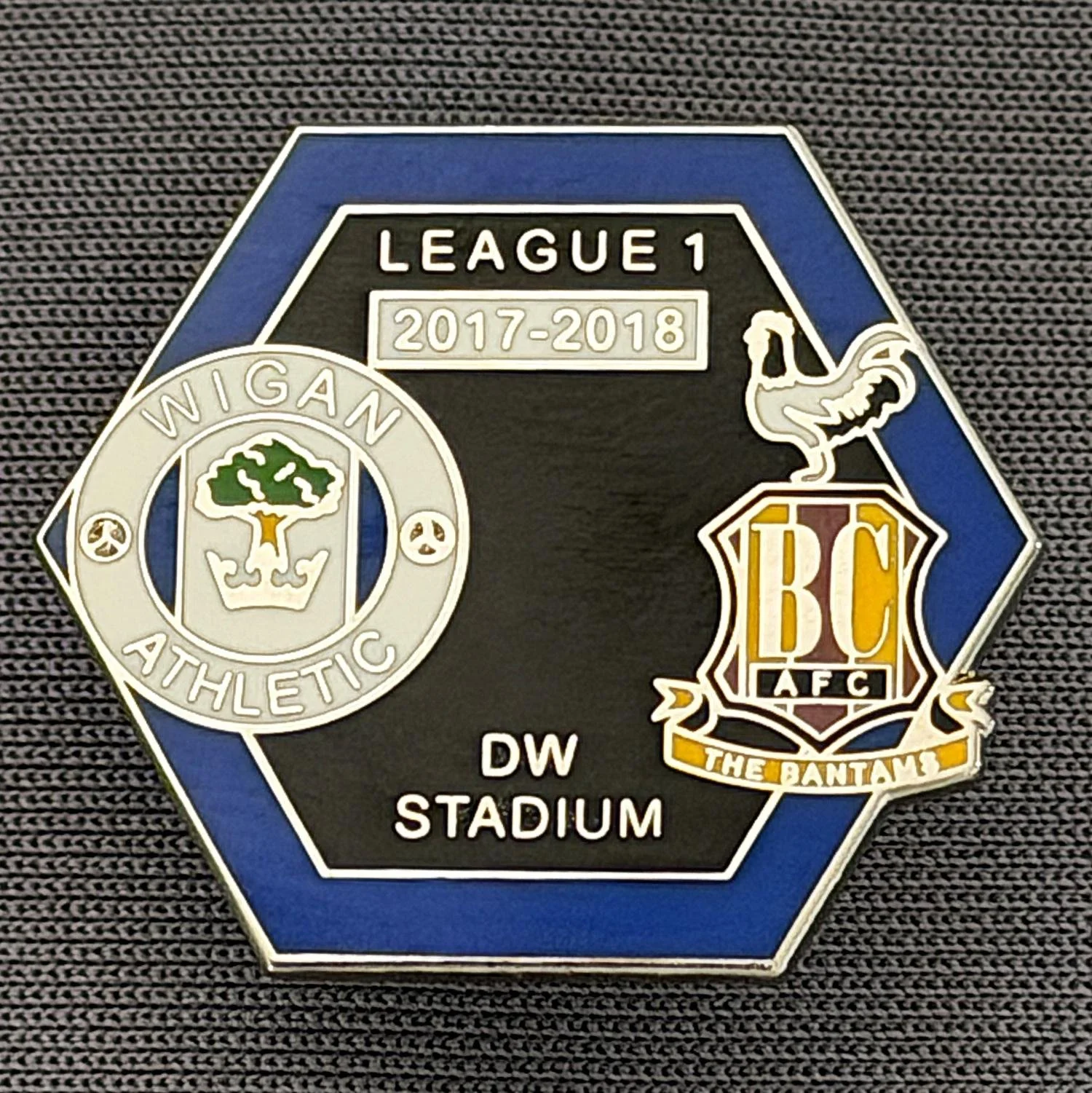 Reference Number: BCOFIX122
Size: H 21.6 mm x W 24.8 mm
Pin Type: Metal Clutch
Plating: Silver
Value: £5
Manufacturer: Unknown
Comments: Wigan v Bradford City, League One 2017/18, Blue & Black Version 