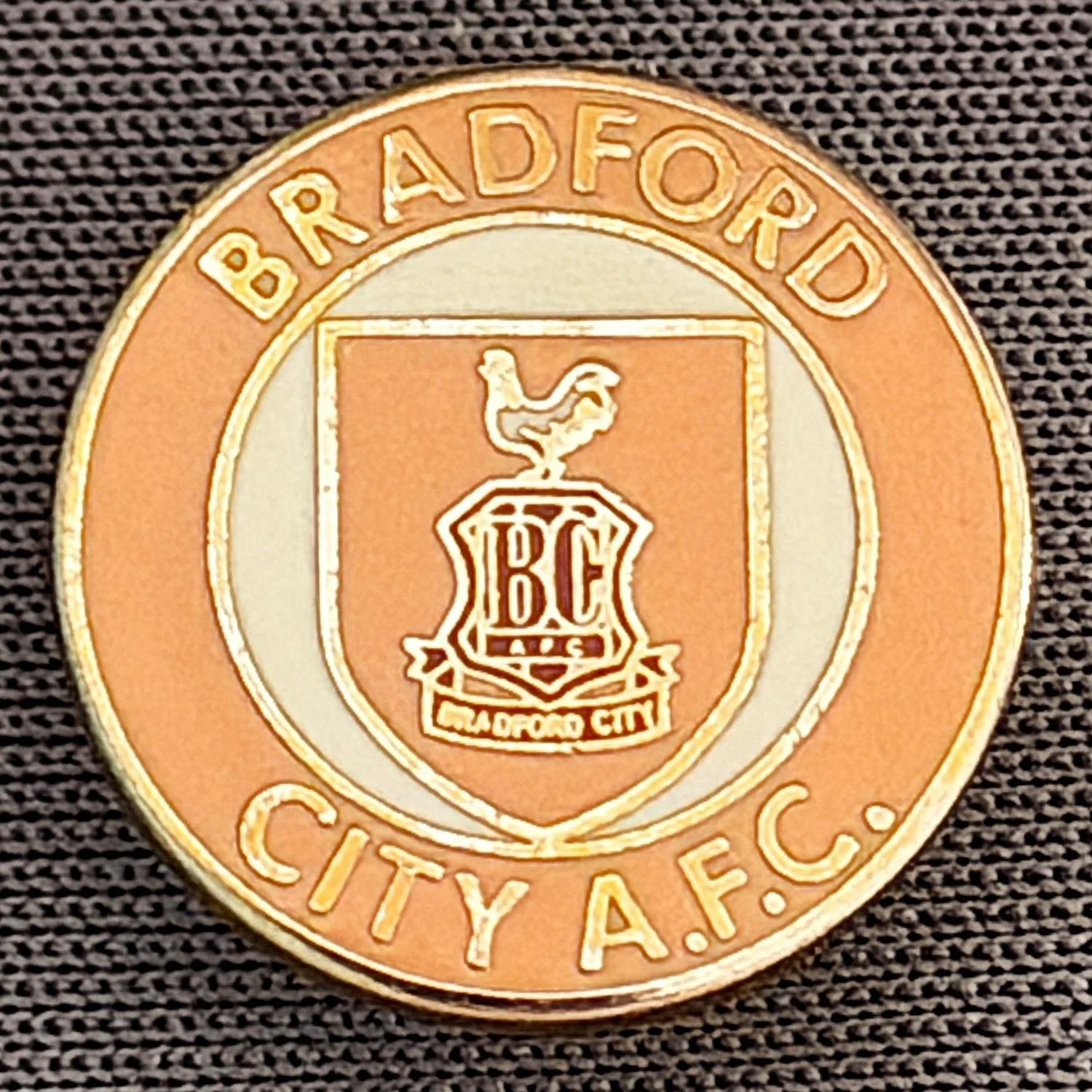 Reference Number: BCC&L020
Size: D 14.7 mm
Pin Type: Brooch Pin
Plating: Gold
Value: £6
Manufacturer: Unknown
Comments: Tiny Circular Amber Shield Logo