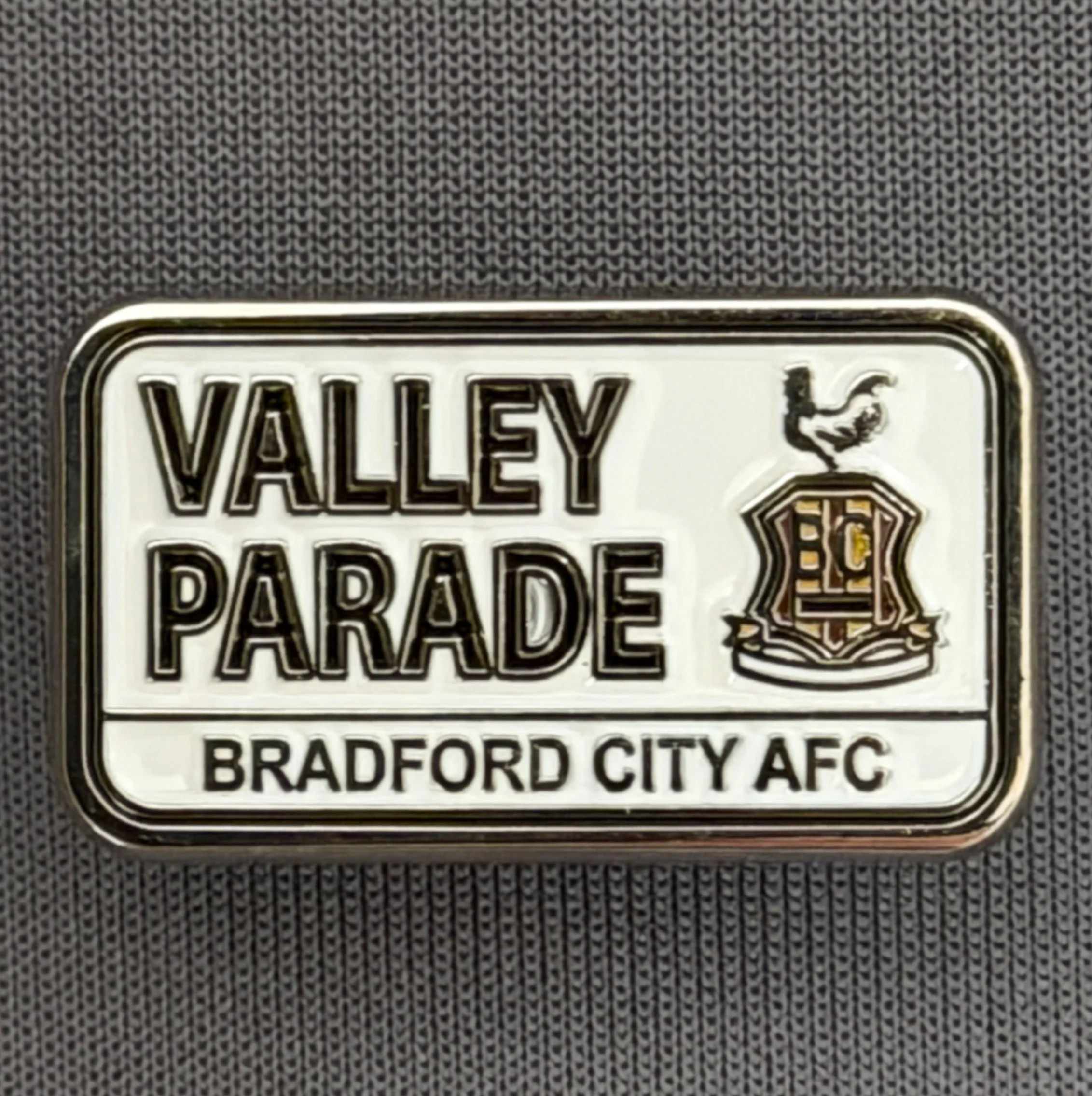 Reference Number: BCVP014
Size: H 14.8 mm x W 25.8 mm
Pin Type: Metal Clutch
Plating: Silver
Value: £6
Manufacturer: Bradford City Shop
Comments: Valley Parade Sign