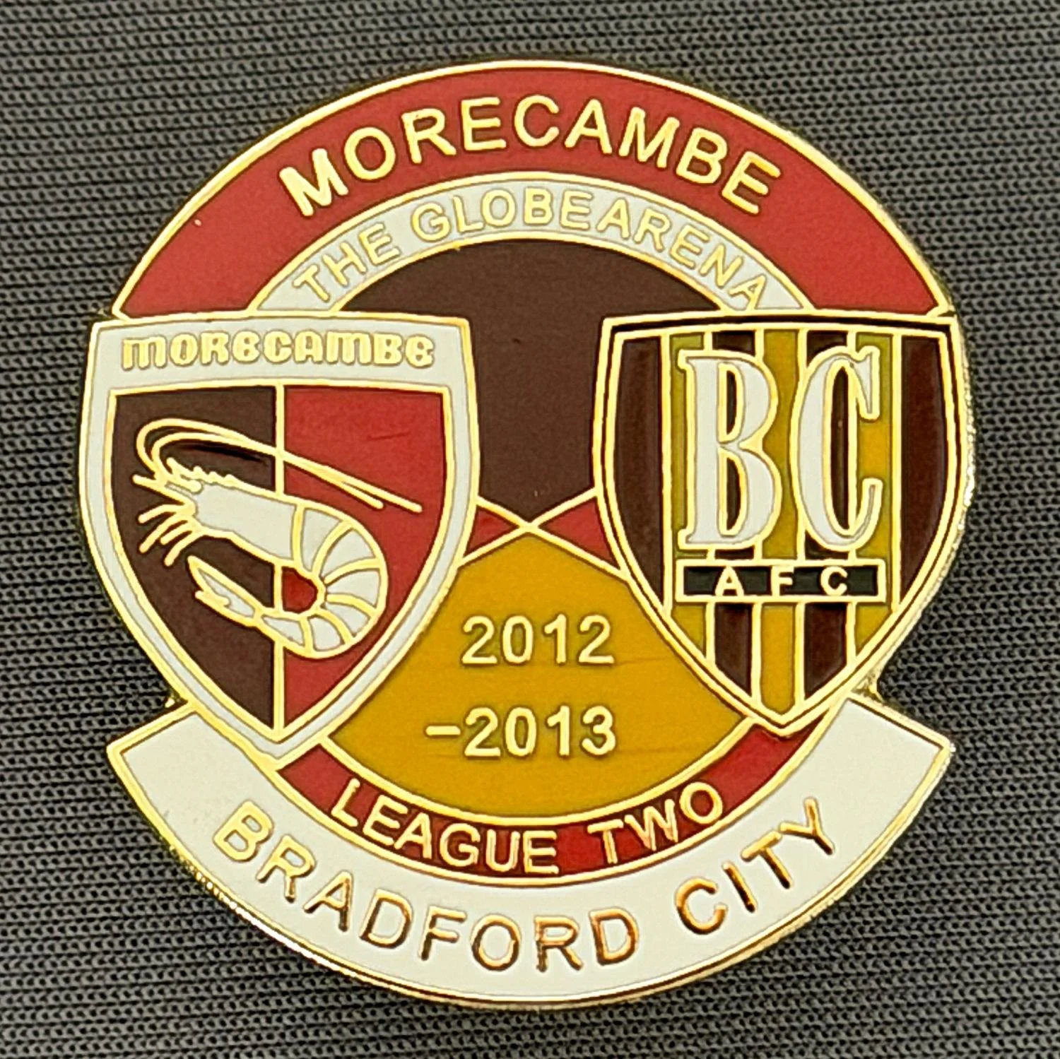 Reference Number: BCOFIX141
Size: H 32.4 mm x W 30.5 mm
Pin Type: Double Rubber Clutch
Plating: Gold
Value: £5
Manufacturer: Unknown
Comments: Morecambe v Bradford City  League Two 2012/13, Red & White Version 