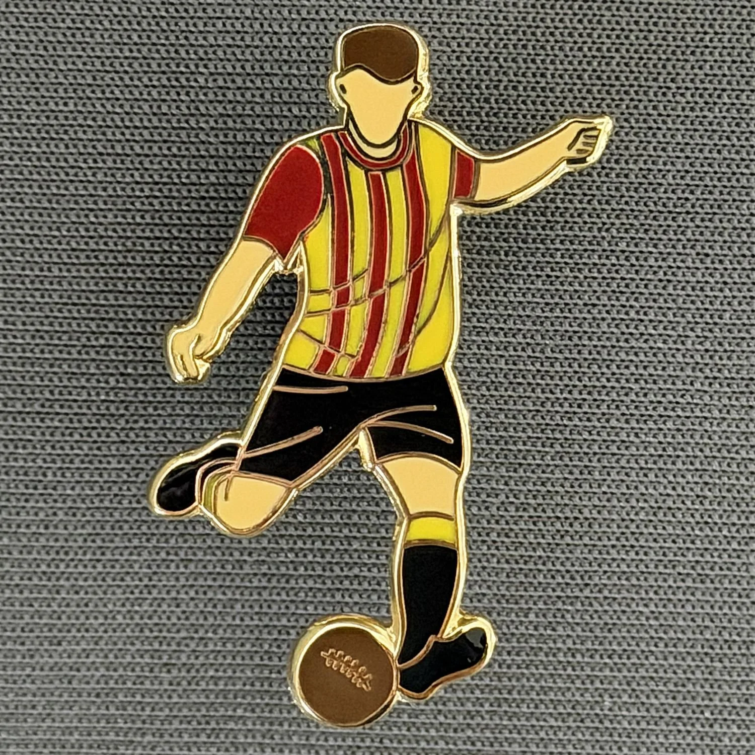 Reference Number: BCKIT099
Size: H 30.6 mm x W 20.2 mm
Pin Type: Metal Clutch
Plating: Gold
Value: £6
Manufacturer: 1000 Flags
Comments: Footballer in Home City Kit 2026
