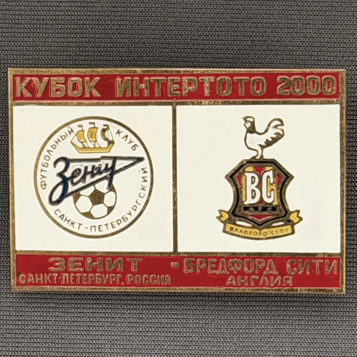Reference Number: BCRUS013
Size: H 29.6 mm x W 44.6 mm
Pin Type: Metal Clutch
Plating: Antique Gold
Value: £12
Manufacturer: Unknown
Comments: Zenit St. Petersburg Inter Toto Cup, Red Top, White Middle, Red Bottom