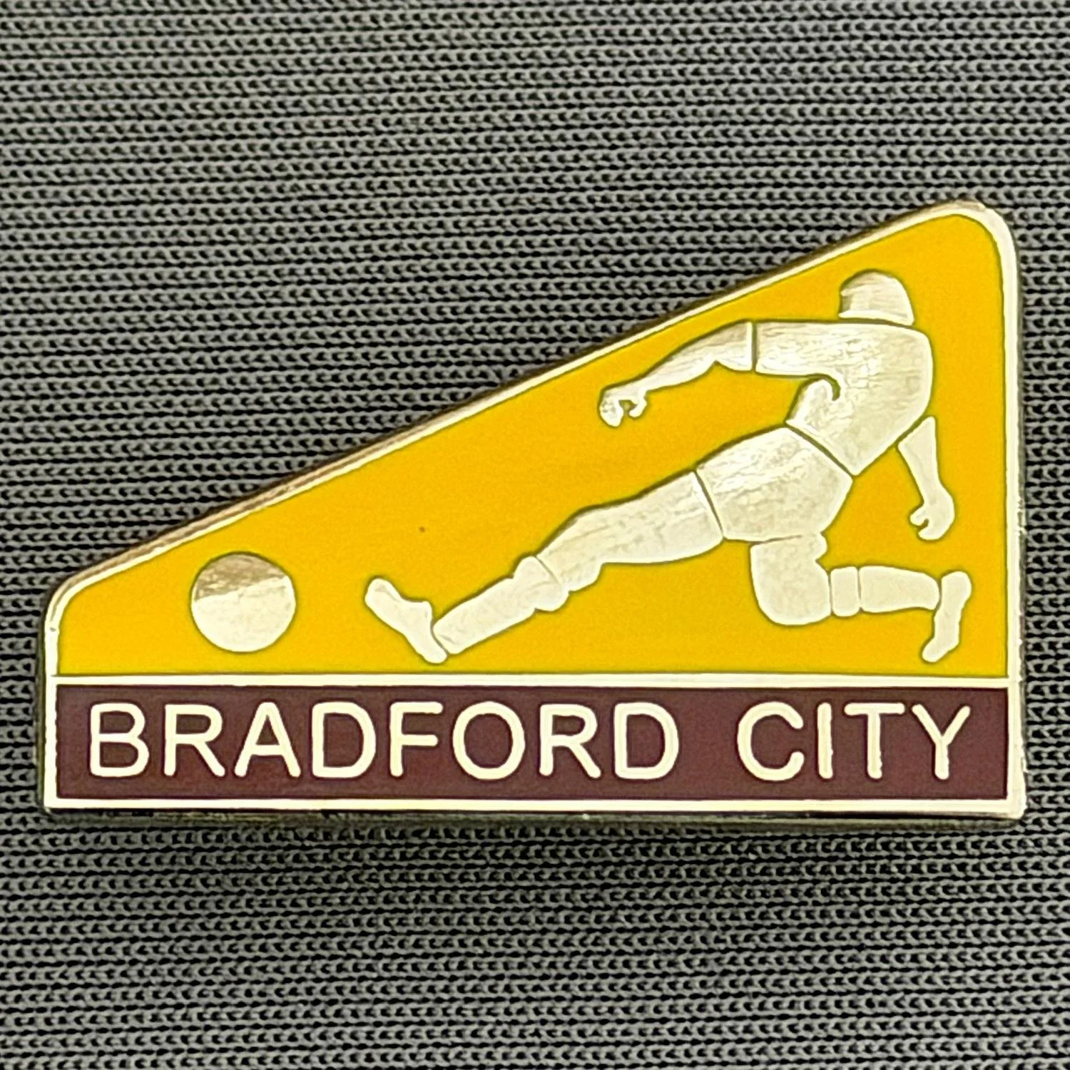Reference Number: BCBCFC078
Size: H 17.3 mm x W 26.2 mm
Pin Type: Brooch Pin
Plating: Silver
Value: £6
Manufacturer: Andy Stokes
Comments: Amber & Claret Bradford City Footballer