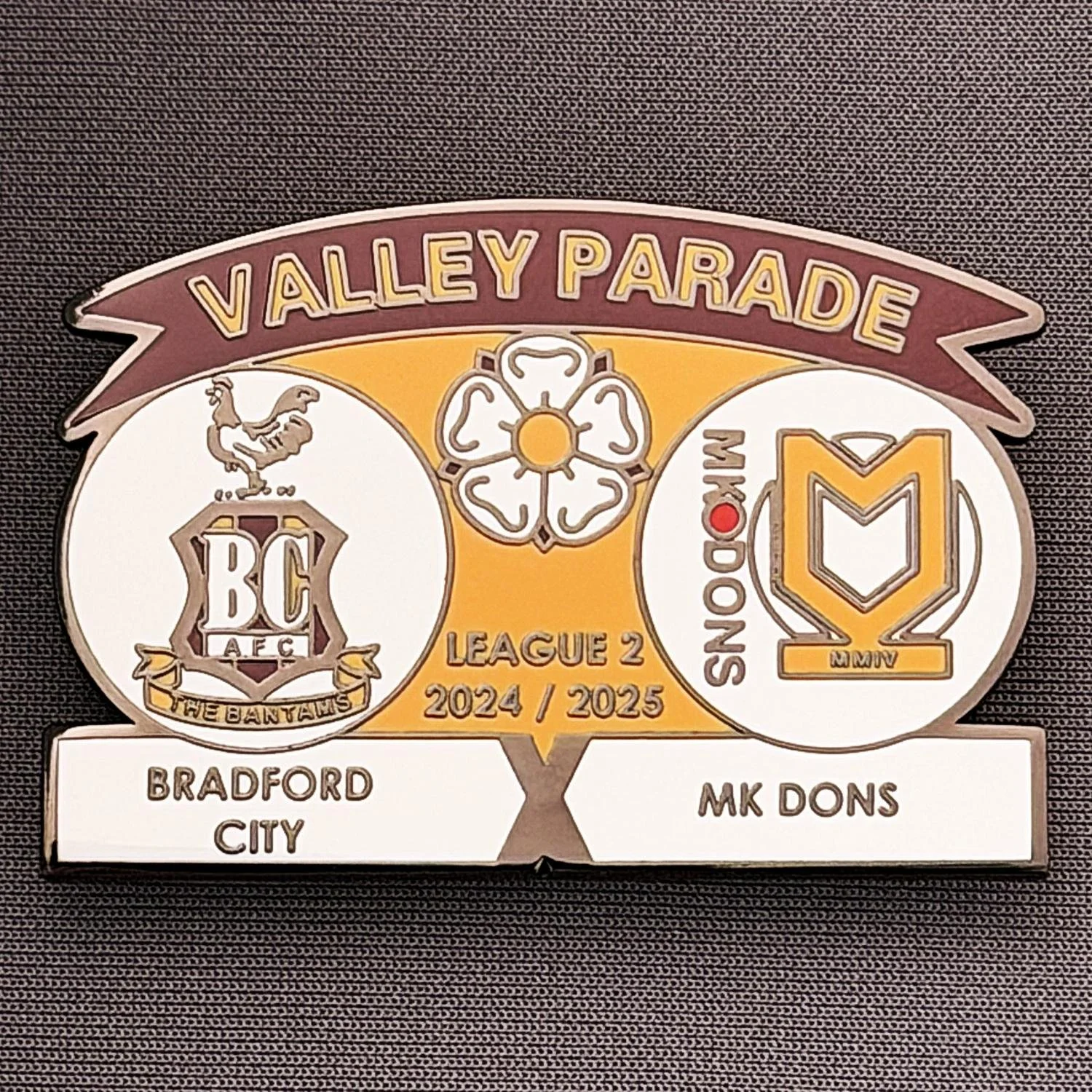 Reference Number: BCFIX432
Size: H 34.3 mm x W 50 mm
Pin Type: Brooch Pin
Plating: Black Nickel
Value: £5
Manufacturer: Unknown
Comments: Bradford City v MK Dons 2024/25.