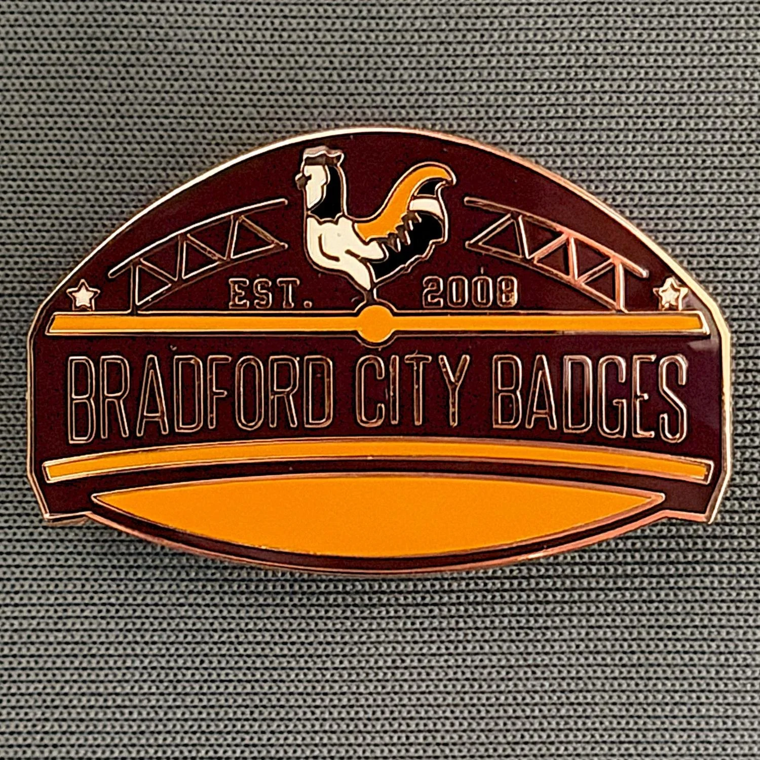 Reference Number: BCUN053
Size: H 20.5 mm x W 32 mm
Pin Type: Metal Clutch
Plating: Copper
Value: £10
Manufacturer: Bradford City Badges
Comments: Bradford City Badges Badge, Limited Edition of 1.