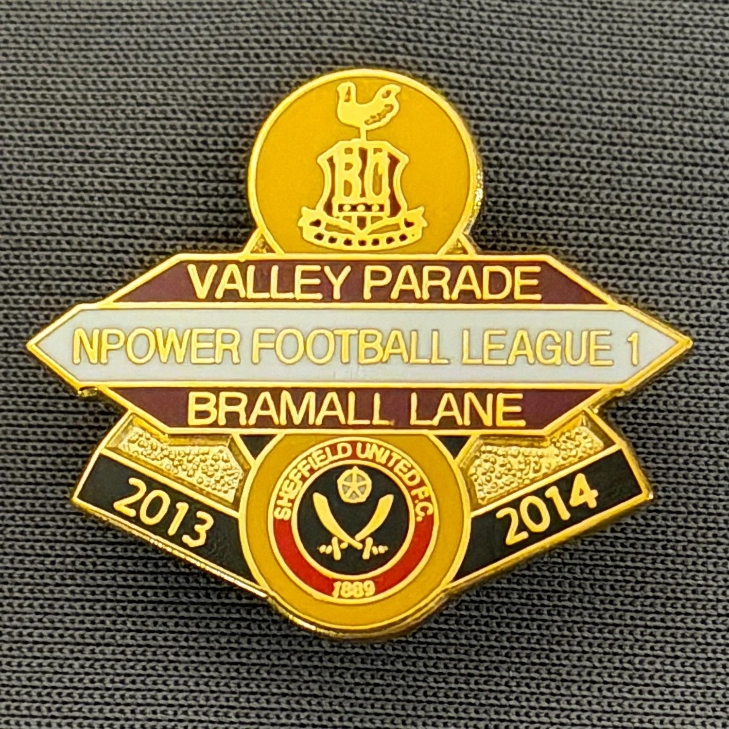 Reference Number: BCOFIX082
Size: H 22.5 mm x W 25.6 mm
Pin Type: Brooch Pin
Plating: Gold
Value: £5
Manufacturer: Unknown
Comments: Bradford City v Sheffield United, League One, Amber, Claret & White Version