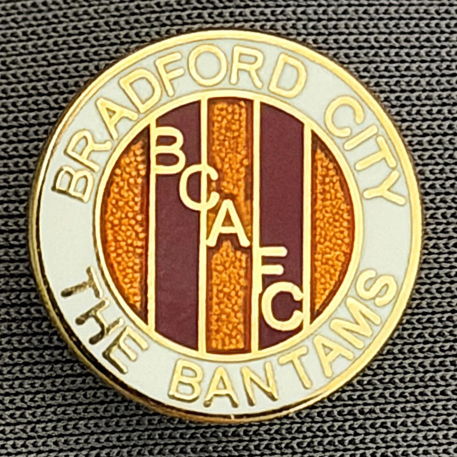 Reference Number: BCBCFC019
Size: D 15 mm
Pin Type: Metal Clutch
Plating: Gold
Value: £6
Manufacturer: Andy Stokes
Comments: Bradford City, BCAFC, The Bantams, White, Claret & Amber Version