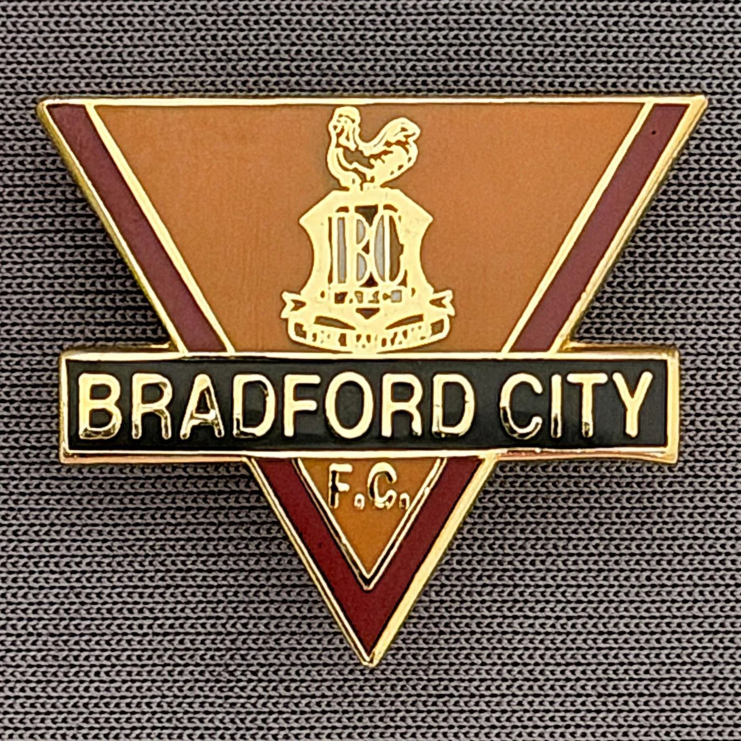 Reference Number: BCC&L042
Size: H 21.7 mm x 25.6 mm
Pin Type: Brooch Pin
Plating: Gold
Value: £8
Manufacturer: Unknown
Comments: Inverted Triangle Bradford City Logo