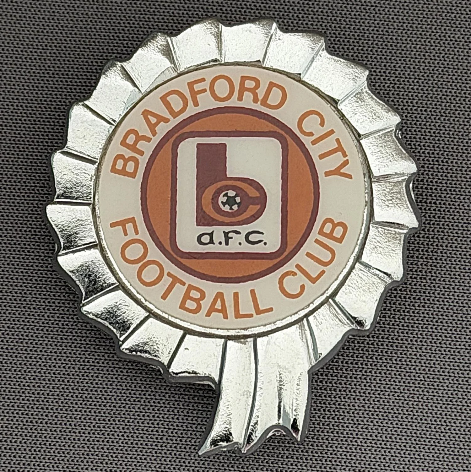 Reference Number: BCC&L003
Size: H 37.4 mm x W 31.4 mm
Pin Type: Brooch Pin
Plating: Silver
Value: £12
Manufacturer: Unknown
Comments: Mid 70s Rosette BC Plastic Insert