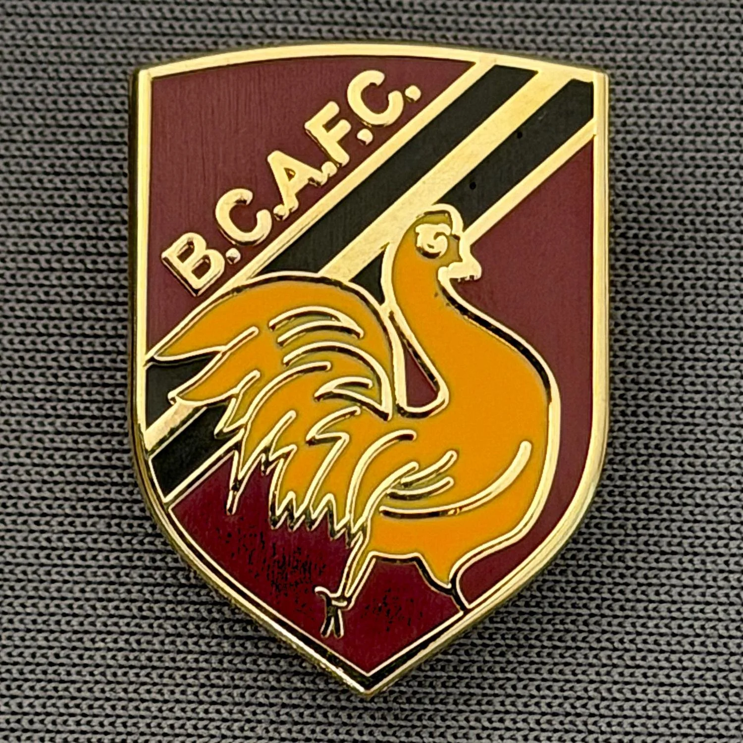 Reference Number: BCBAN052
Size: H 22.9 mm x W 16.8 mm
Pin Type: Brooch Pin
Plating: Gold
Value: £6
Manufacturer: Unknown
Comments: Claret, Amber & Black Bantam Shield, Small Version 