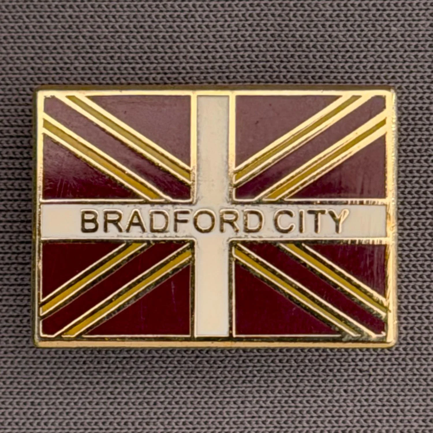 Reference Number: BCFLA033
Size: H 14.7 mm x W 20.5 mm
Pin Type: Brooch Pin
Plating: Antique Gold
Value: £6
Manufacturer: Not Known
Comments: Union Flag Bradford City, Claret Version
