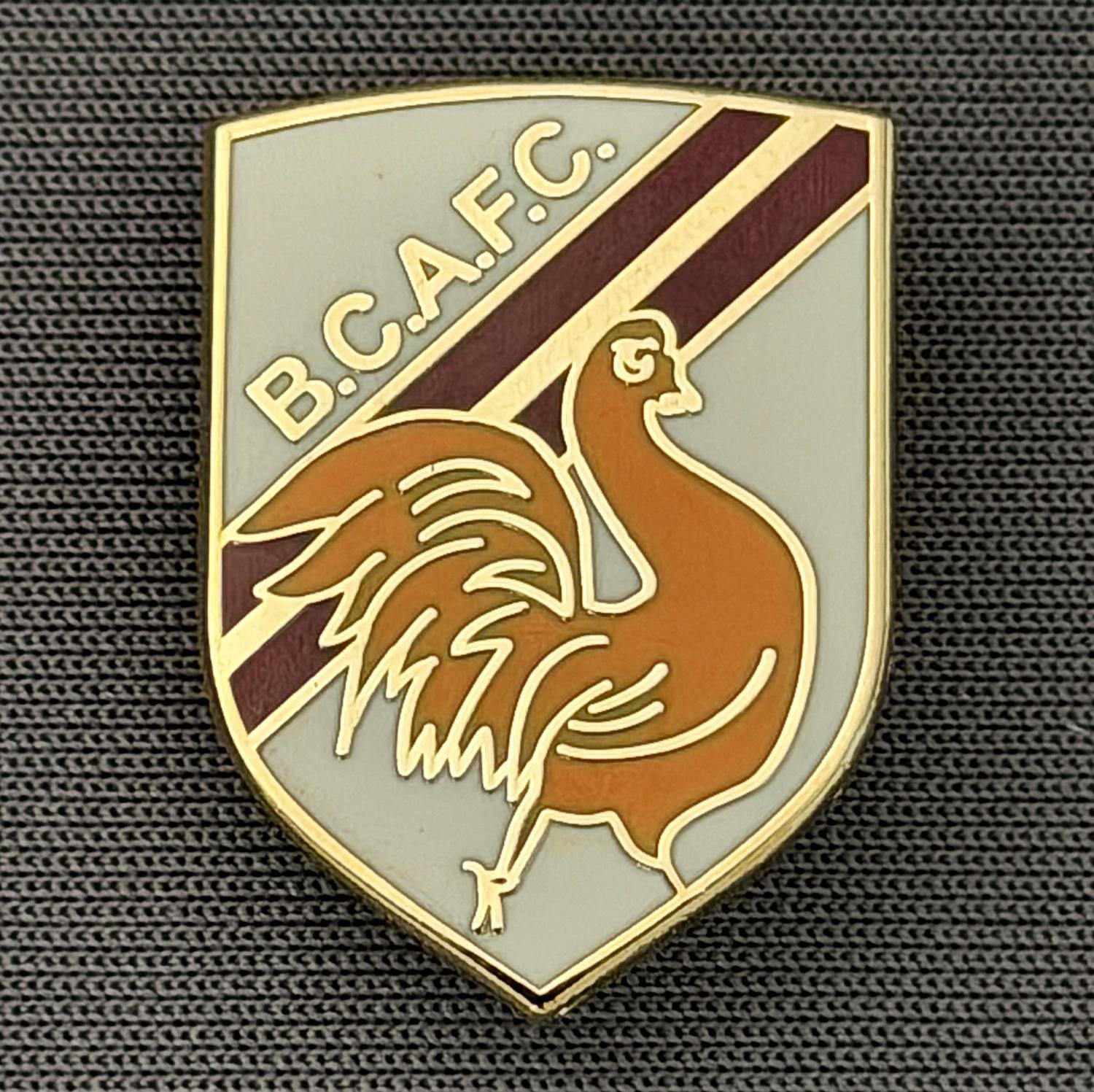 Reference Number: BCBAN054
Size: H 22.9 mm x W 16.8 mm
Pin Type: Brooch Pin
Plating: Gold
Value: £6
Manufacturer: Unknown
Comments: White, Claret & Amber Bantam Shield, Small Version 