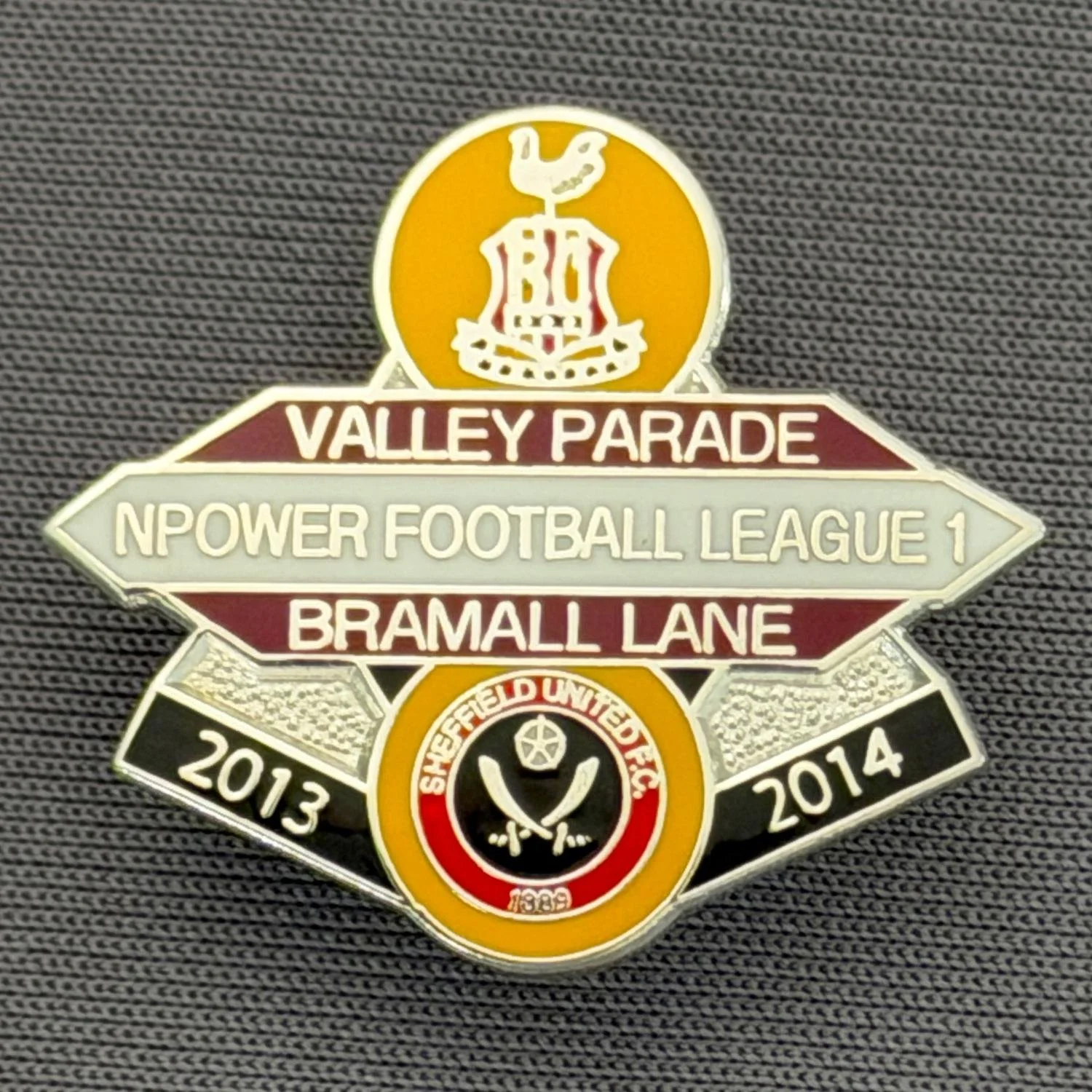 Reference Number: BCOFIX083
Size: H 22.5 mm x W 25.6 mm
Pin Type: Brooch Pin
Plating: Chrome
Value: £5
Manufacturer: Unknown
Comments: Bradford City v Sheffield United, League One, Amber Claret & White Version