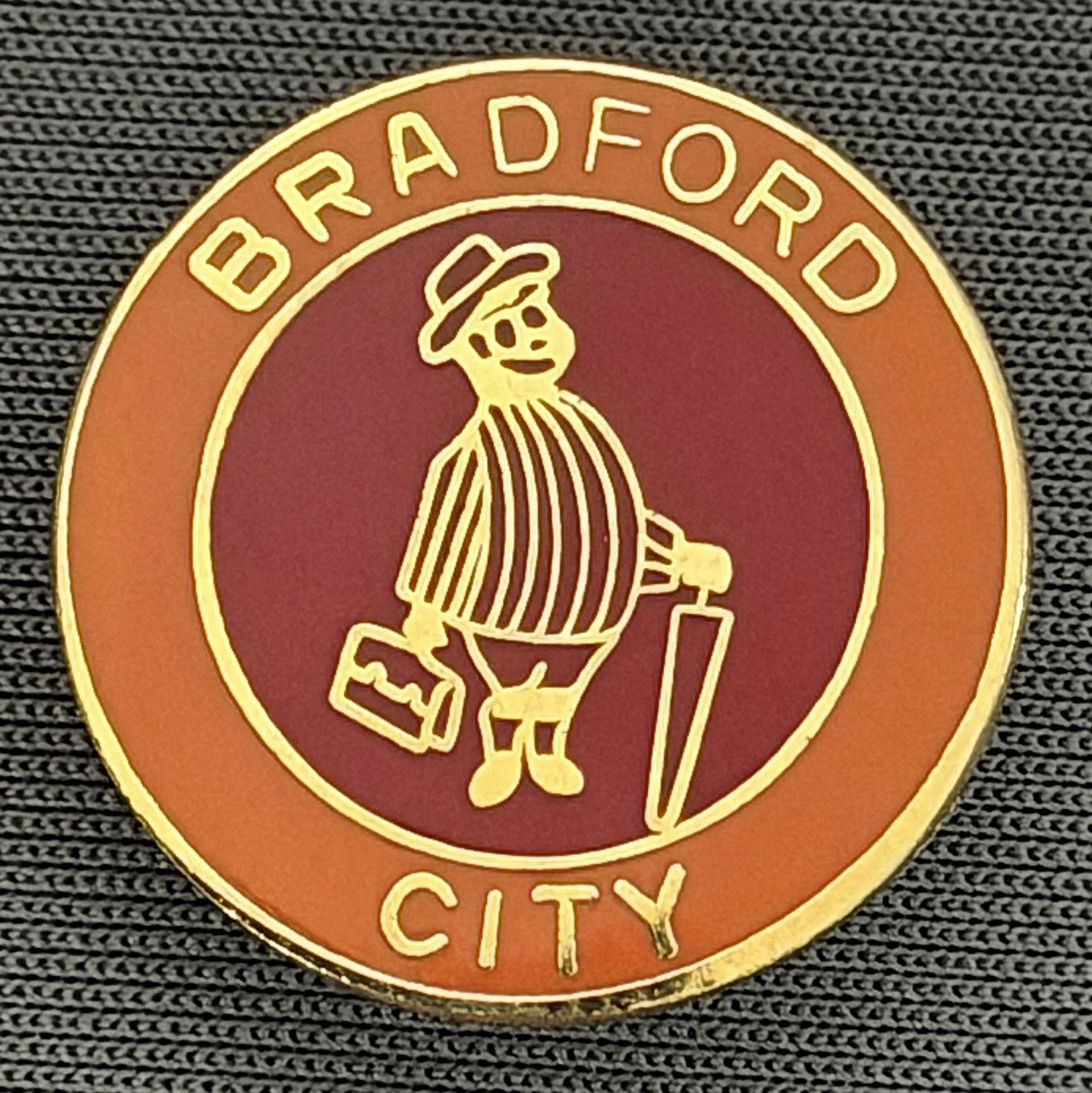 Reference Number: BCGEN021
Size: D 20 mm
Pin Type: Brooch Pin
Plating: Gold
Value: £8
Manufacturer: Unknown
Comments: Circular Amber & Claret City Gent