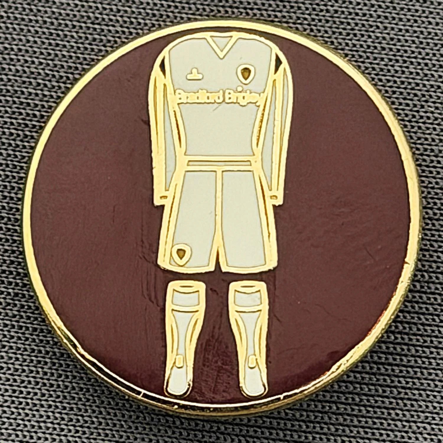 Reference Number: BCKIT075
Size: D 22.1 mm
Pin Type: Brooch Pin
Plating: Gold
Value: £6
Manufacturer: Unknown
Comments: White City Kit, Claret Circular Surround